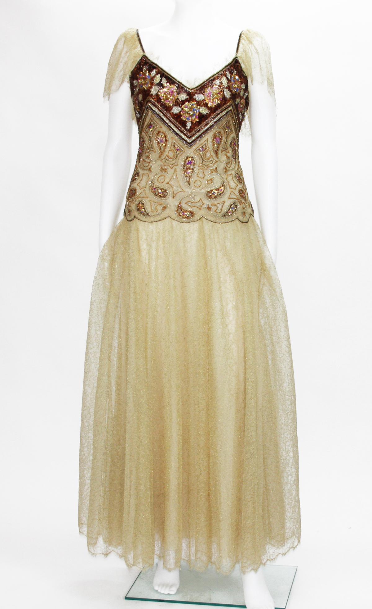 Christian Dior Automne-Hiver 1980 Dress
Embellished with beads and sequins. Lace has metal gold thread through. Boned bodice with attached interior waist belt. Triple skirt silk lining. Every level on corrugated scarf finished with gold tone