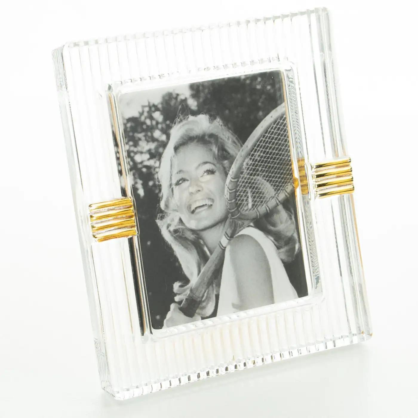 Christian Dior designed this decorative picture photo frame for the Home Collection in the 1990s. The thick molded crystal slab has striped carving and gilt application. The easel and back are in pink gilded metal with an engraved 