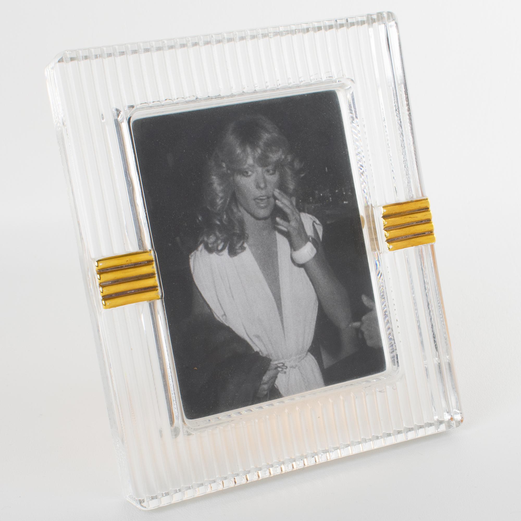 This stunning modernist picture frame was designed for the Christian Dior Home Collection. The piece was crafted in Japan circa 1990. The thick molded crystal slab has striped carving and gilt application. The easel and back are made of anodized