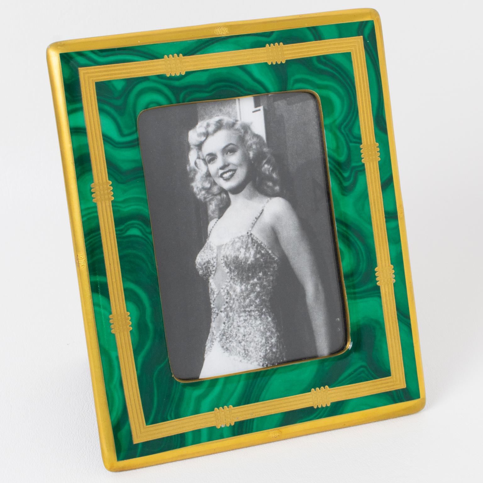 Ce joli cadre photo décoratif a été conçu pour la collection Christian Dior Home dans les années 1980. La délicate dalle en céramique présente un motif texturé de type malachite et une application dorée. Le chevalet et le dos sont en tissu noir