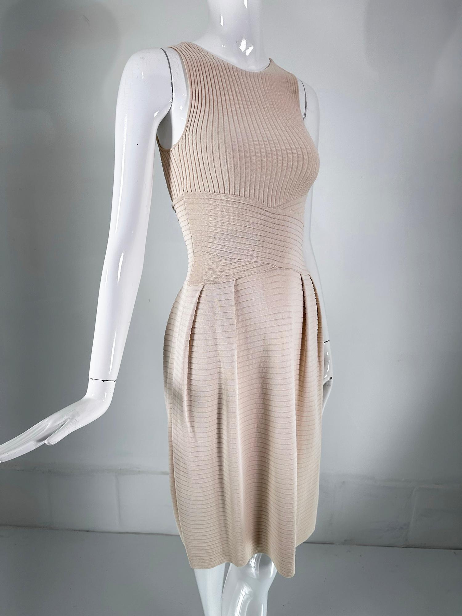 Christian Dior Paris 2010, beige silky ribbed knit dress with racer style bodice, cross ribbed waist with open pleats at the hip fronts & back giving the skirt a bell shape. The dress is unlined & closes at the side with an invisible zipper. The