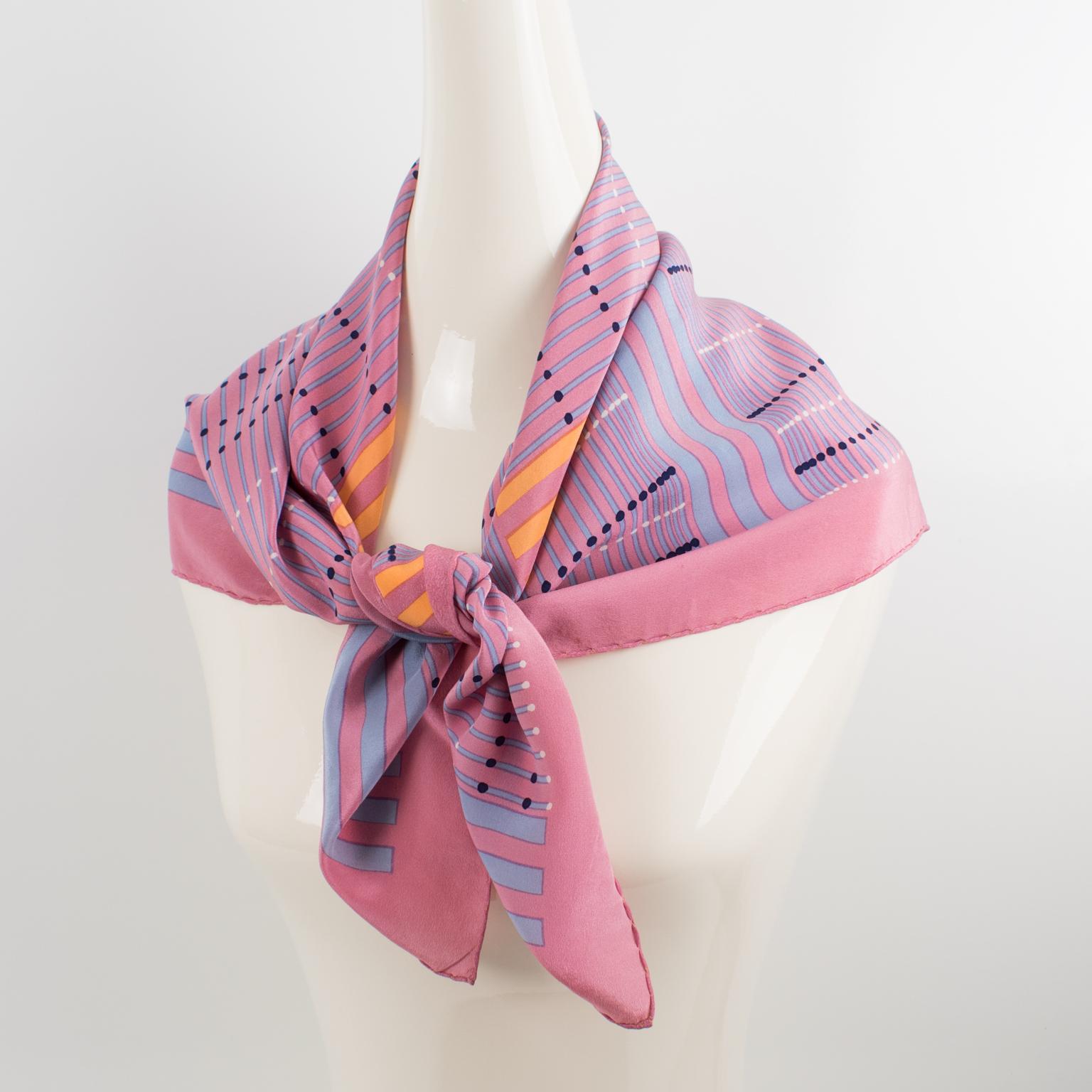 This lovely silk scarf by Christian Dior Paris in pink and orange colors features a geometric design print. The Christian Dior's signature name is in the lower right corner. The combination of colors is bright and vibrant, with ballet sleeper pink,