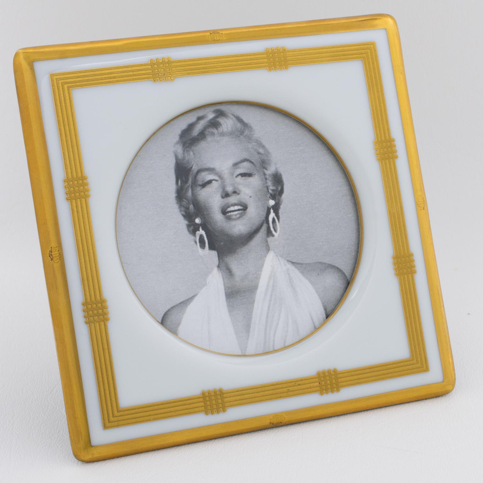 This stunning Christian Dior Paris white and gilded ceramic picture frame is a rare piece from the 1980s Dior Home Collection. Crafted from delicate white ceramic with a beautiful gold application, it features felted black fabric for the easel and