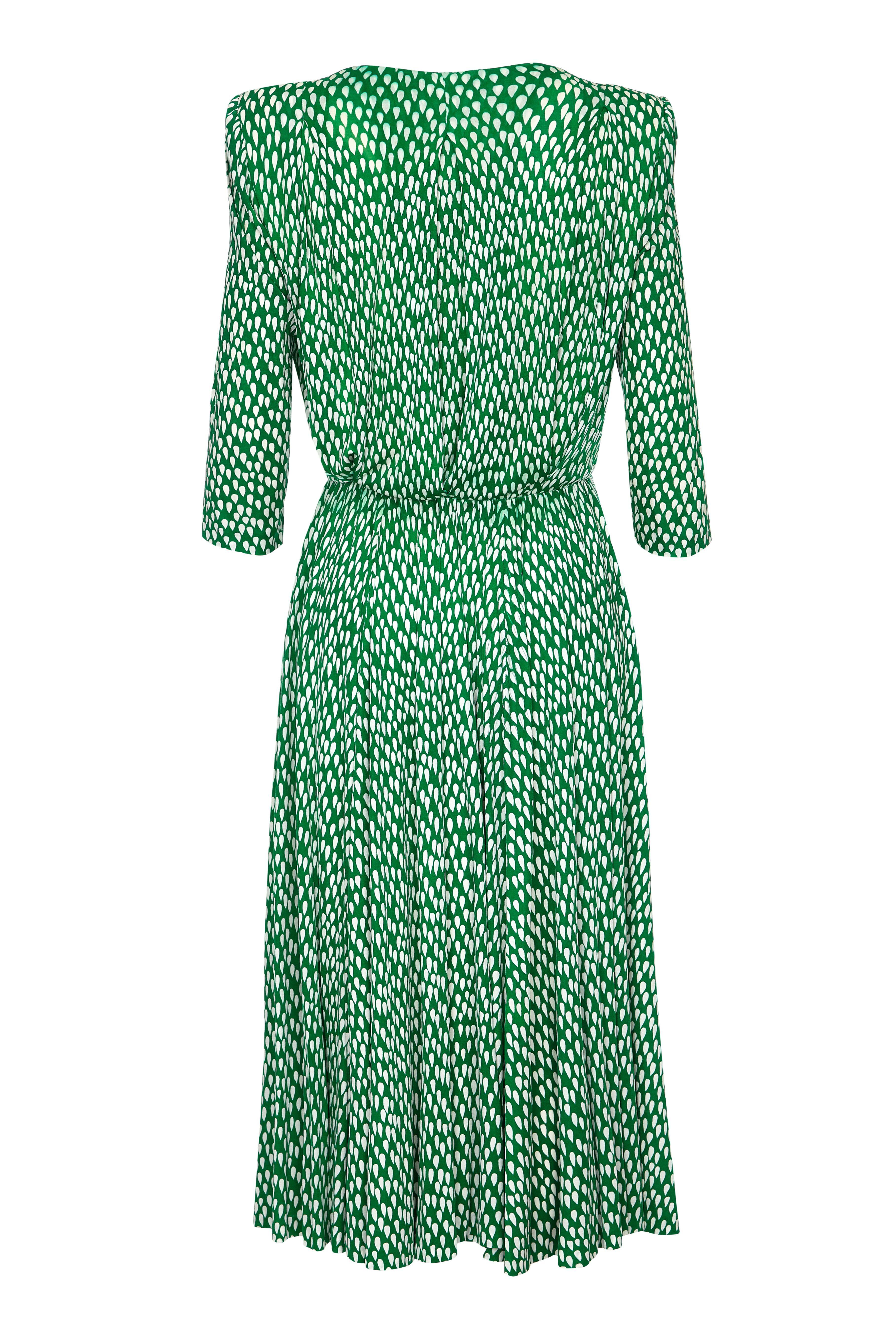 This beautiful silk dress in forest green by Christian Dior has the demi - couture Patron label and is circa mid 1980s. The soft silk fabric has an inverted teardrop design and is cut with a plunging crossover bodice and full circle calf length