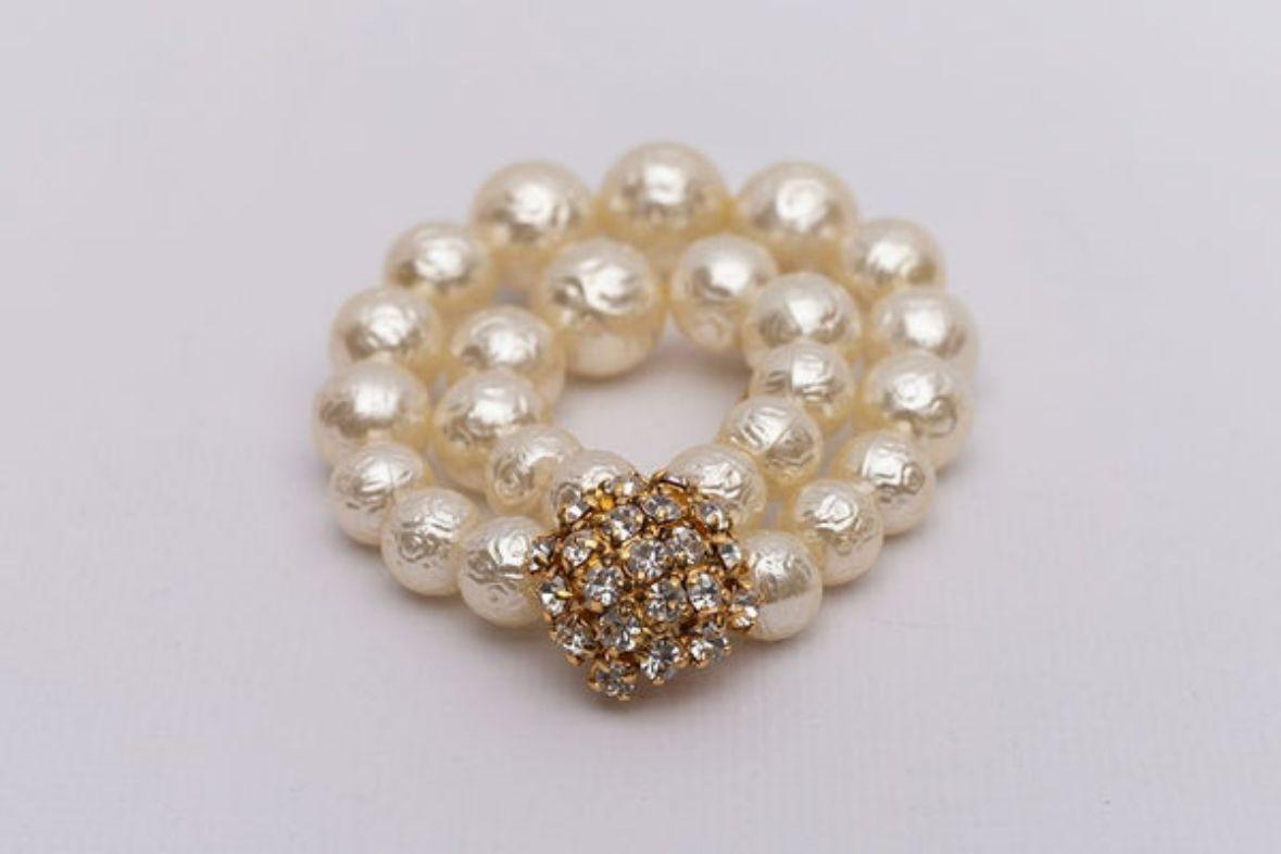 Christian Dior - Brooch in gilded metal, rhinestones, and pearly beads.

Additional information:
Dimensions: 8 cm x 6 cm (3.15