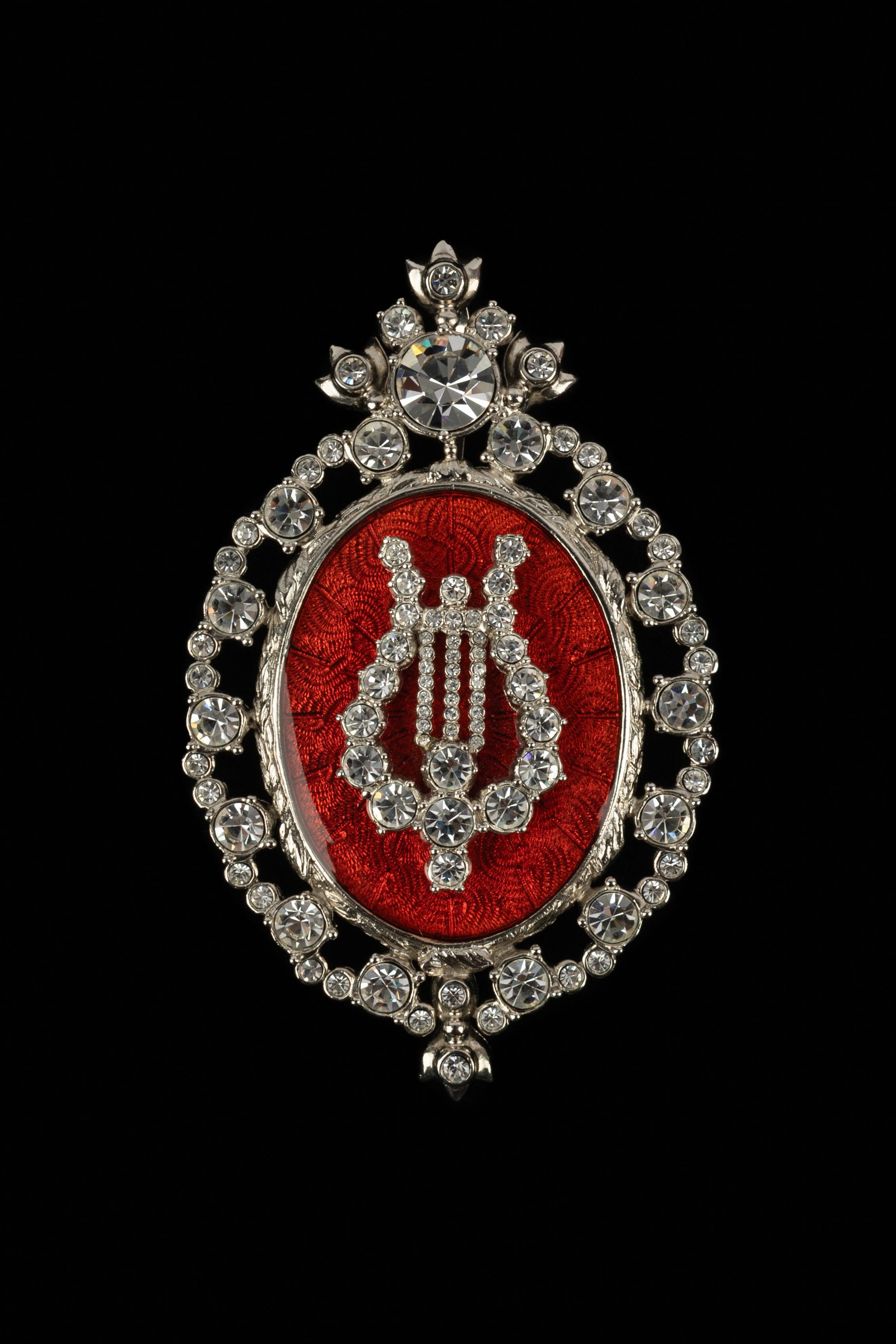 DIOR - Broche colgante de metal plateado adornado con strass y esmalte rojo.

Estado:
Muy buen estado

Dimensiones:
Altura: 10,5 cm

SKU:BR116