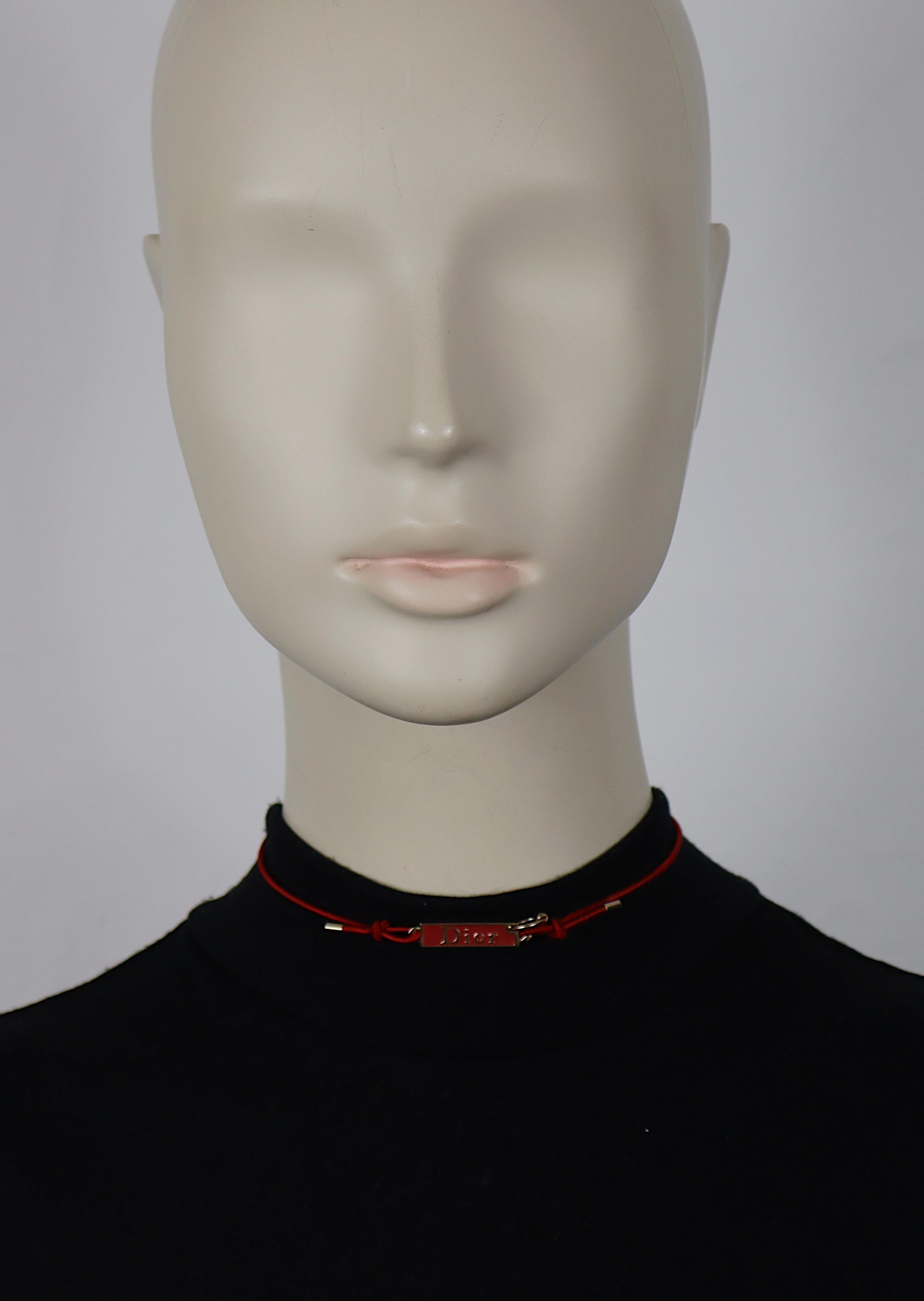 CHRISTIAN DIOR choker necklace featuring a pierced gold tone DIOR logo embellished with red enamel, red elasticated strap.

Lobster clasp closure.
Adjustable length.

Embossed DIOR.

Indicative measurements (without extension)  : adjustable length