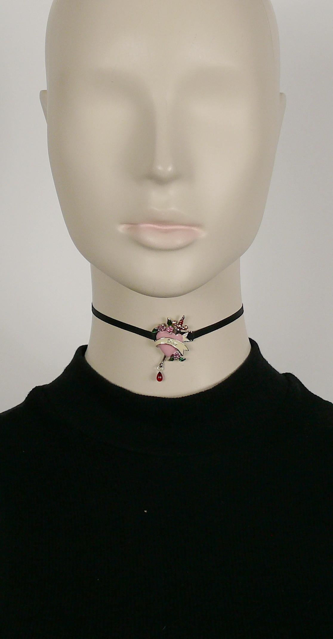 CHRISTIAN DIOR choker necklace featuring an enameled pierced heart with sword embellished with multicolored crystals and a red glass drop.

Black satin ribbon ties in the back.
One size fits all.

Marked DIOR.

Comes with original box (used
