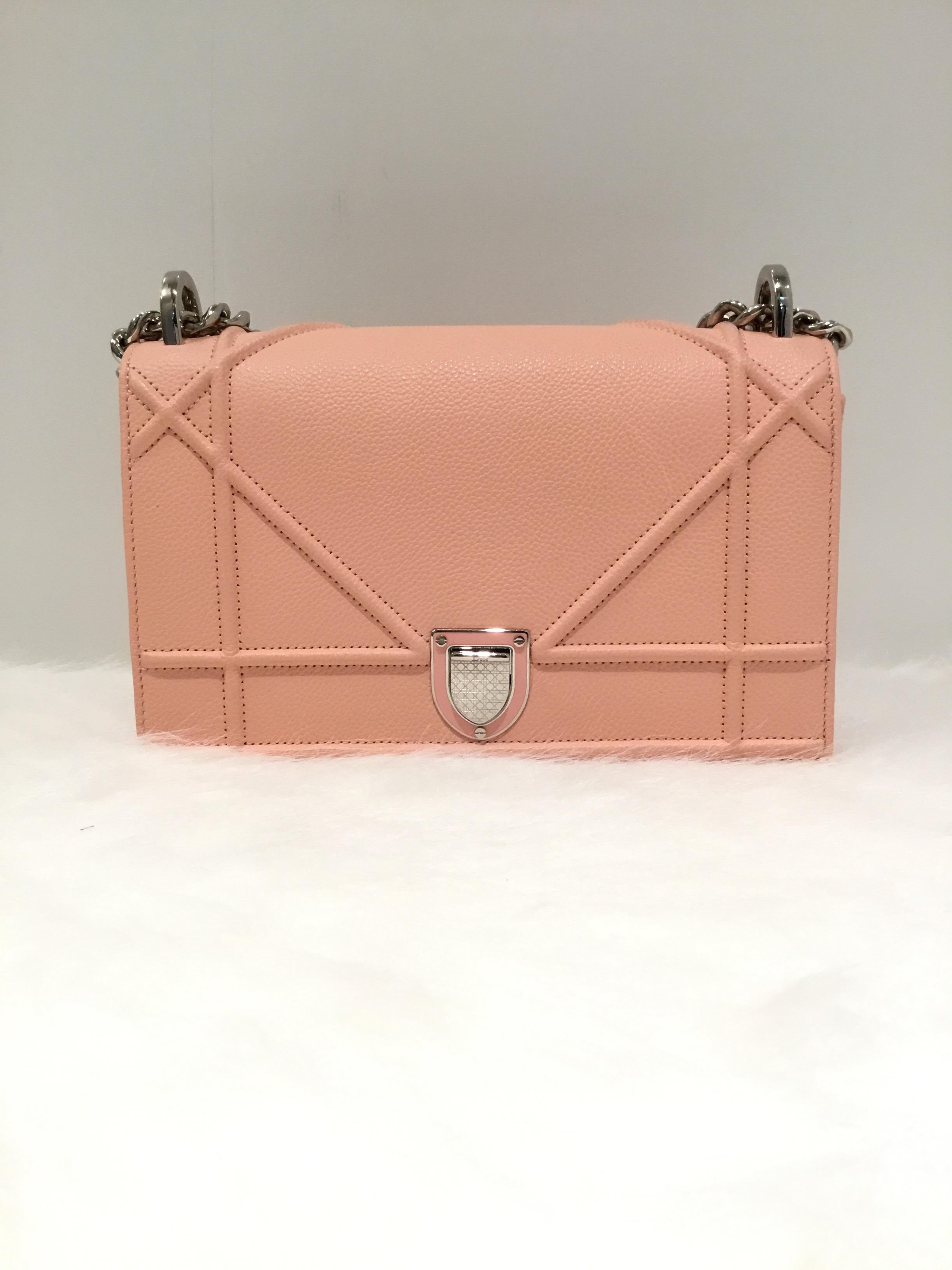 Christian Dior “Diorama” bag goes from evening to day in a soft pink grained leather throughout with silver-tone hardware and a push-in clasp with flap closure. Interior is fully lined with one zipper pocket and one slip pocket. Light wears to the