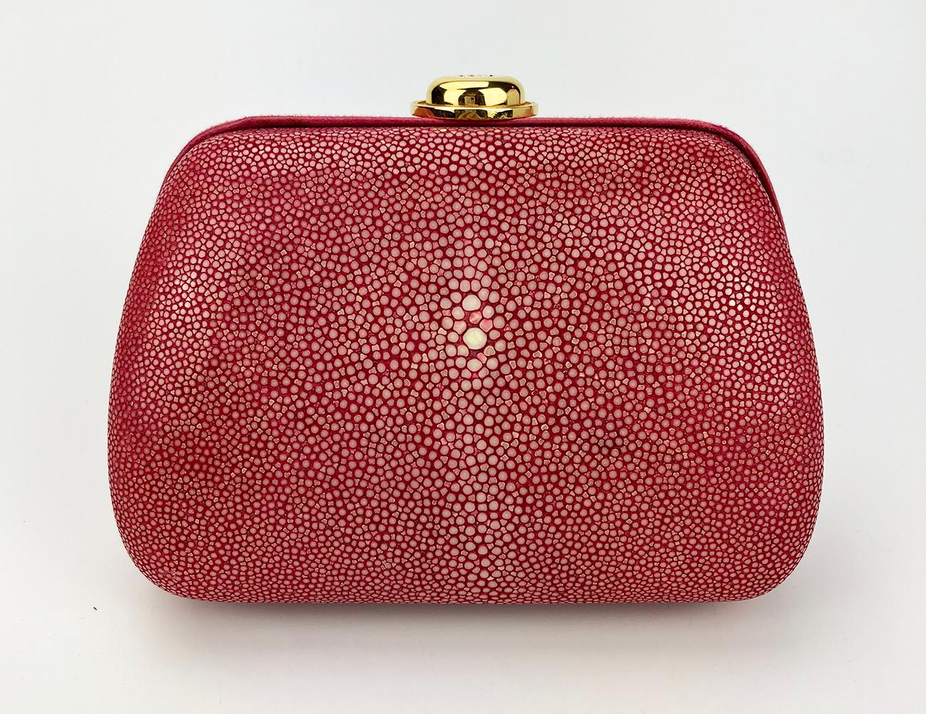 Christian Dior Pink Galuchat Stingray Clutch in good condition. Coral pink stingray exterior trimmed with dark pink satin edges and gold hardware. Top lift latch closure opens to a purple silk lined interior with an attached gold chain shoulder