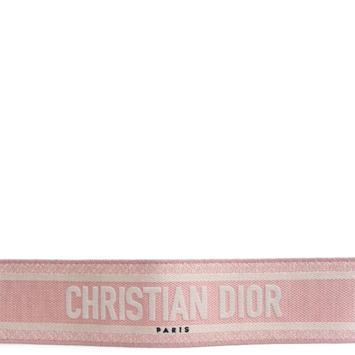 100% authentisches Christian Dior Taschenband aus hellrosa und ecrufarbenem Canvas mit goldfarbenen Schließen und schwarzem Lederbesatz. Wurde getragen und weist leichte Druckstellen an den inneren Lederteilen auf. Insgesamt in ausgezeichnetem