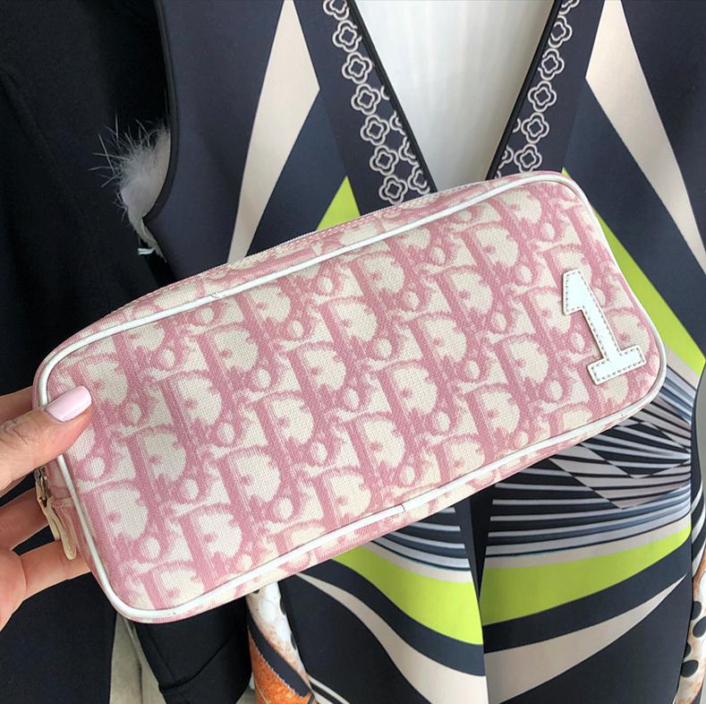 Christian Dior Pink Monogram Logo Small Pouch Bag.  Pink and white monogram canvas toiletry or make-up zippered case.  Logo zipper-pull, fabric lined interior.  Measures 9 x 4.25 x 3.5”. Excellent pre-owned condition. 
