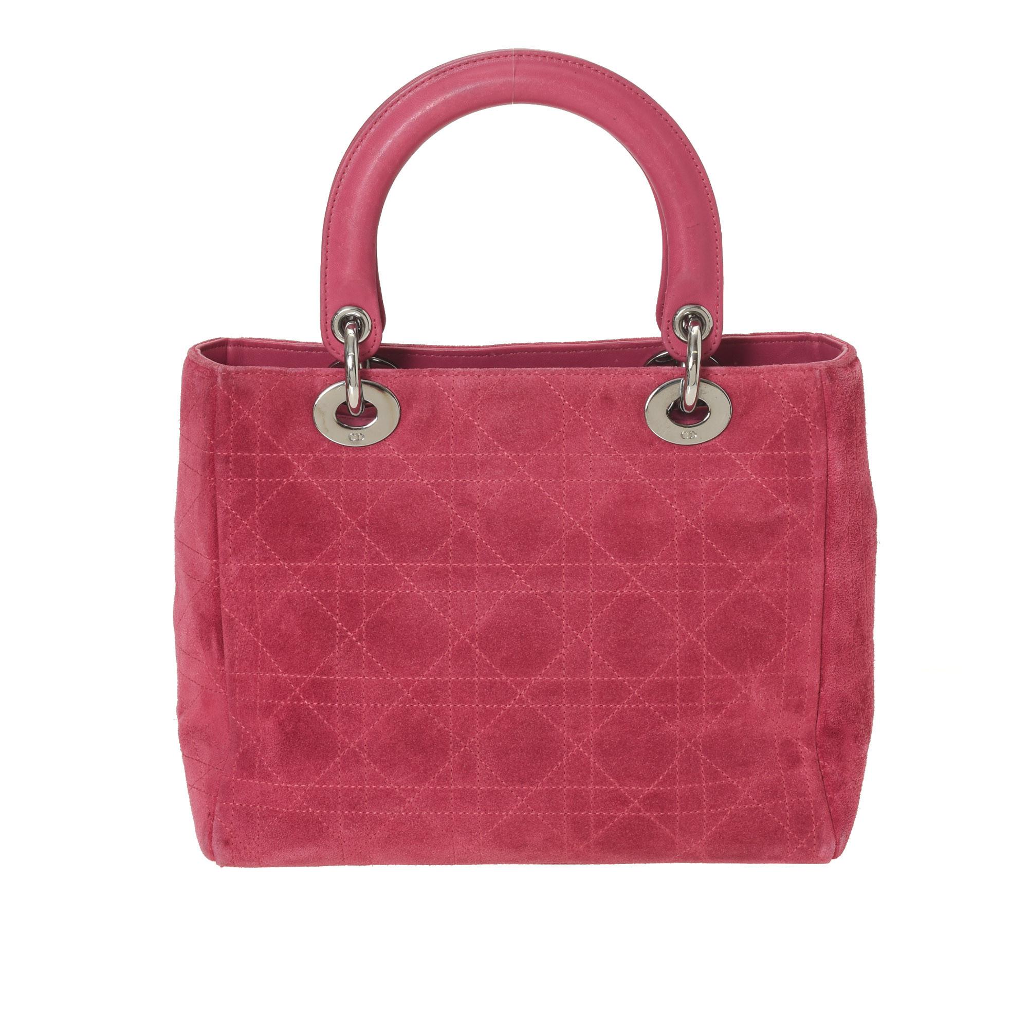 This pink Lady Dior medium handbags has been crafted from leather and suede and it carries the signature Cannage quilt. It is equipped with a black Oblique nylon interior and two top handles. The gorgeous piece is complete with the classic Dior
