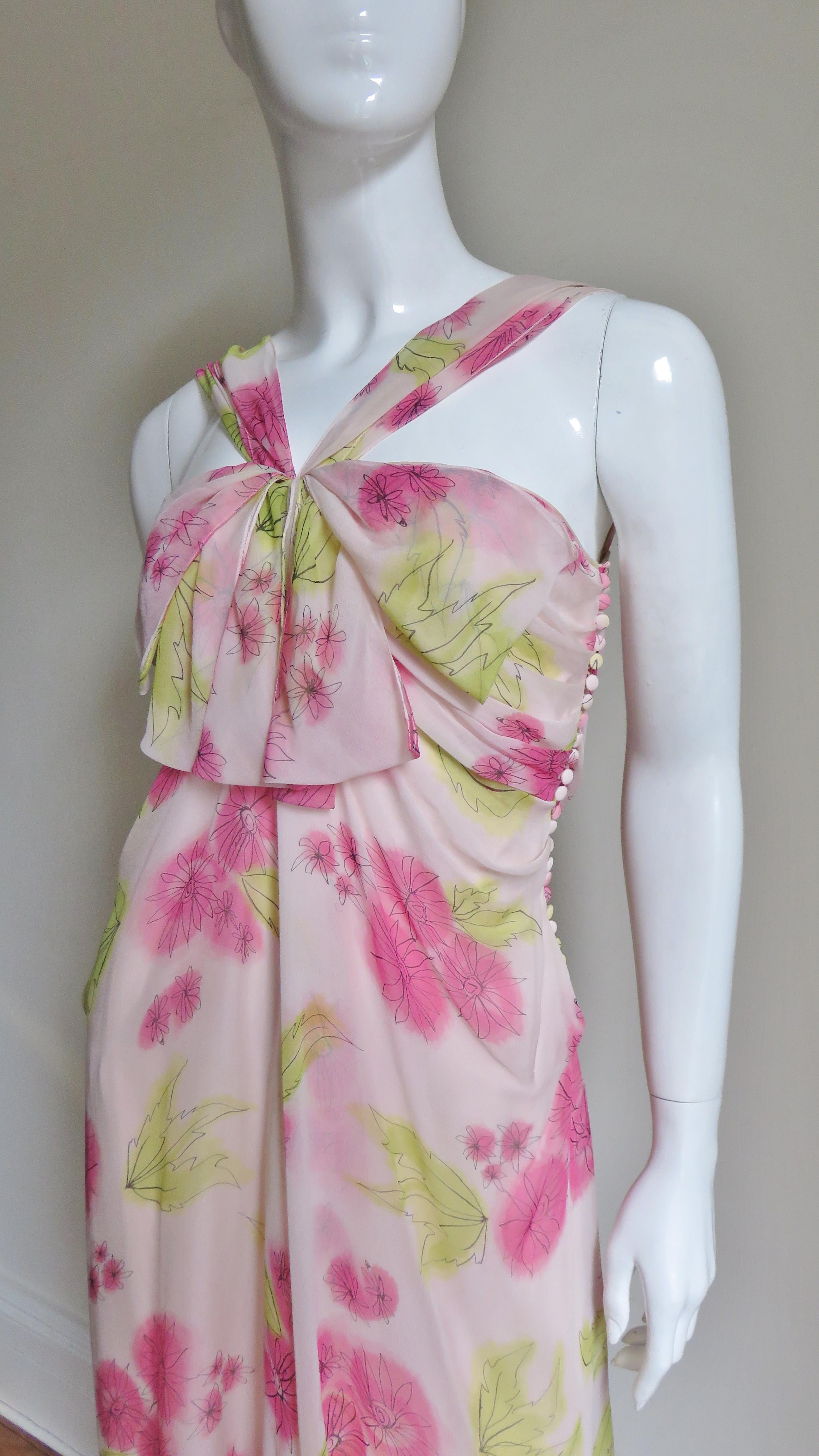 A beautiful blush pink silk dress with green and bright pink flowers by John Galliano for Christian Dior.  It has ruched straps forming a front V, the skirt falls in gentle folds to the hem and there are the signature Dior self covered buttons and