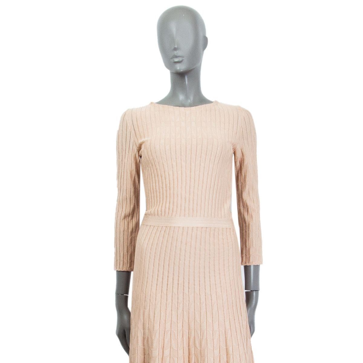 authentic Christian Dior A-line knit dress in nude viscose (70%), cotton (20%), polyamide (10%) with round neck-line and 3/4 length sleeves. Closes with a zipper at the side and has a waist-line band to underline the silhouette. Lined in nude