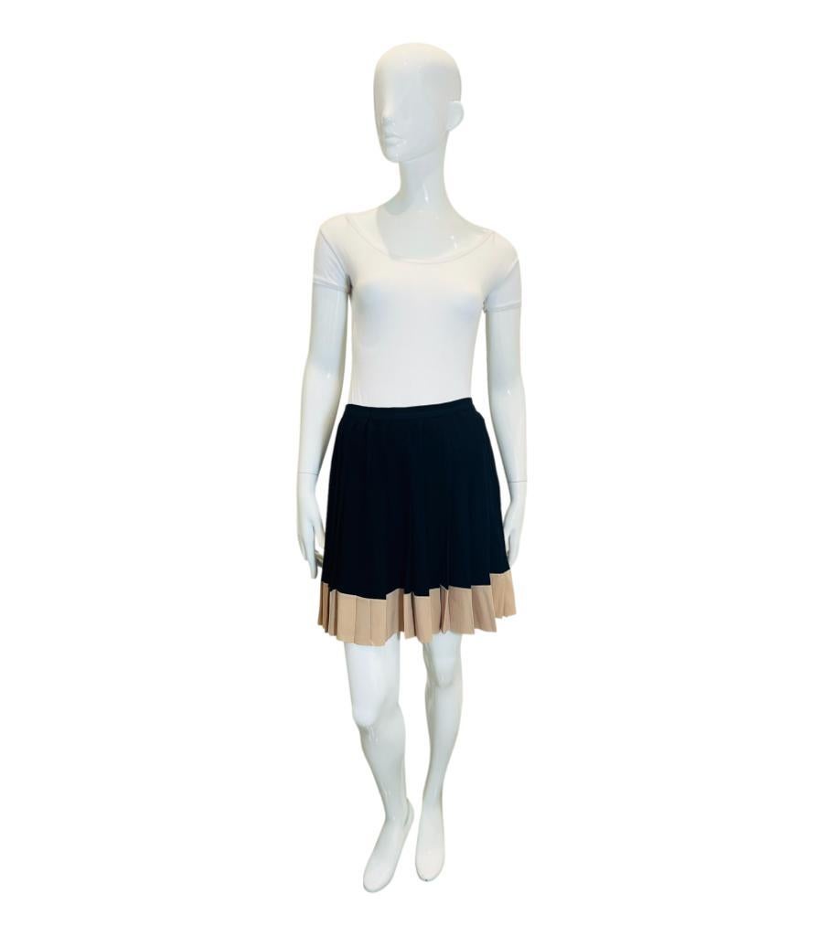 Christian Dior Pleated Silk Skirt

Classy skirt crafted in black silk and designed with contrast beige trim.

Detailed with flared cut enhanced by pleats and mini length with snap button closure along the side.

Size – 38FR

Condition – Very