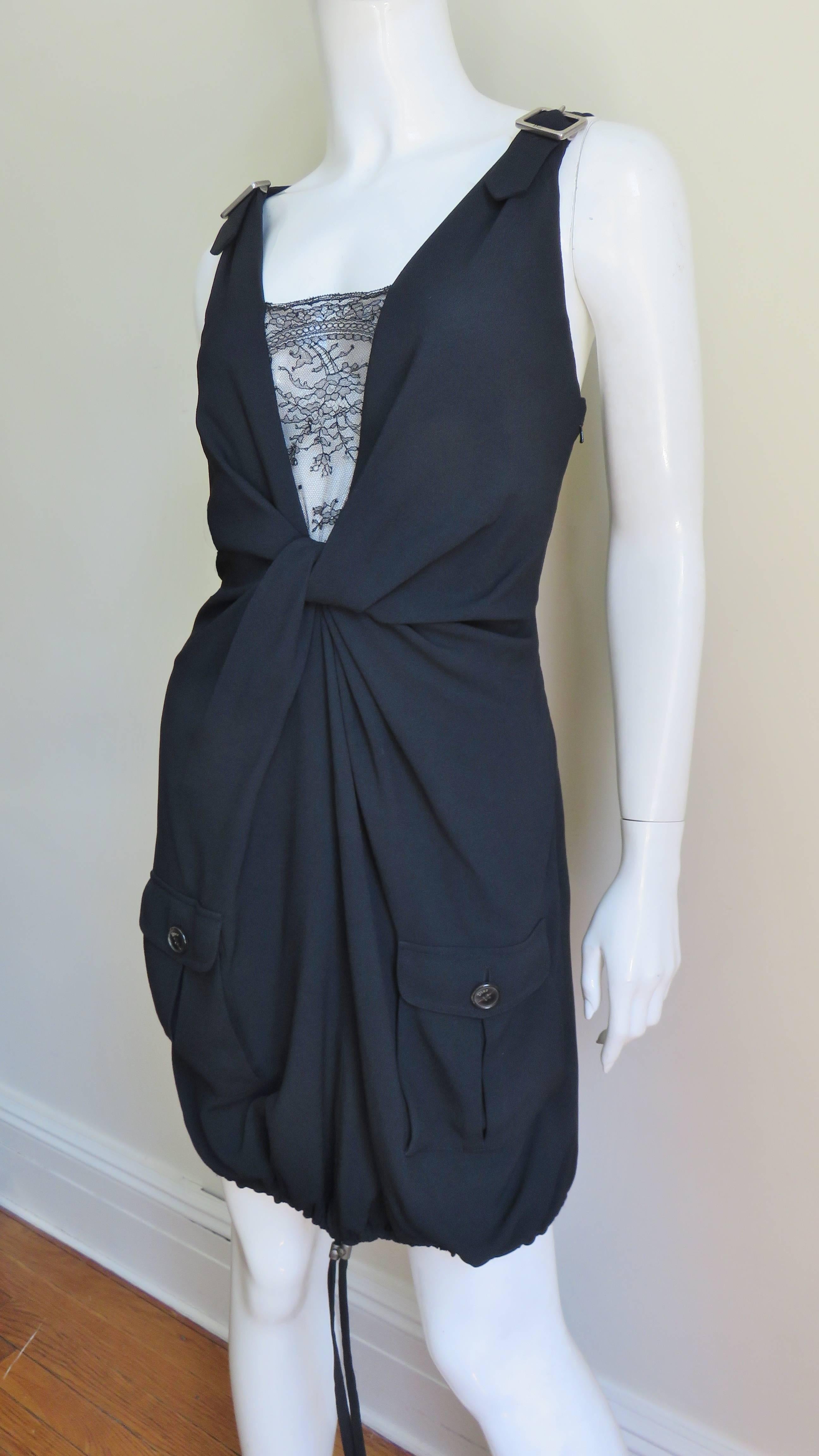 A fabulous black silk dress from John Galliano for Christian Dior.  It has adjustable straps with silver Dior inscribed buckles at the shoulders and back of each strap plus a center front sheer black lace panel at the plunging neck. There is front