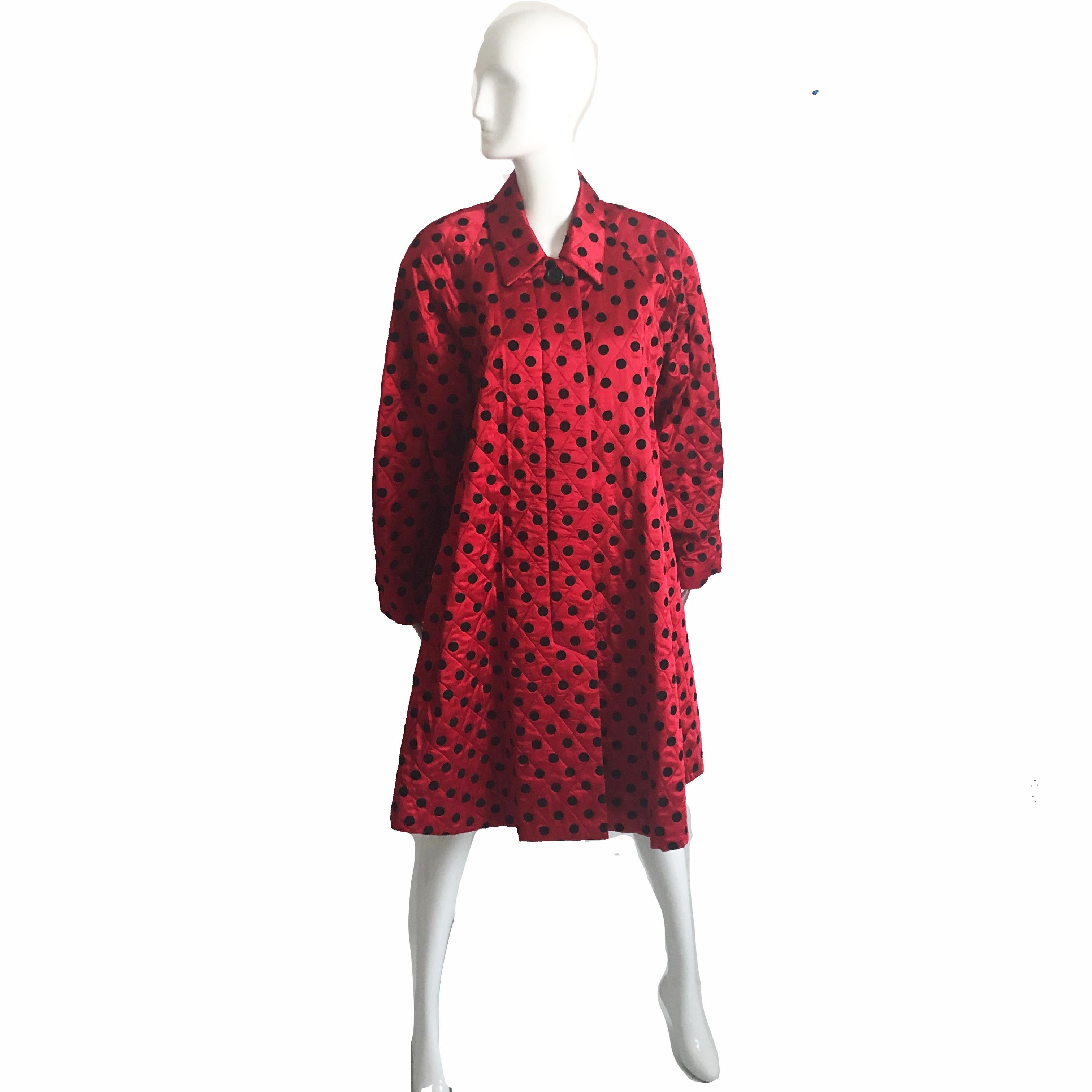 This fabulous evening coat was made by Christian Dior, most likely in the early 80s.  Made from silk satin, it features a black polka dot motif, dolman sleeves and a wide swing hem.  Fully lined with shoulder pads and fastens with one button at the
