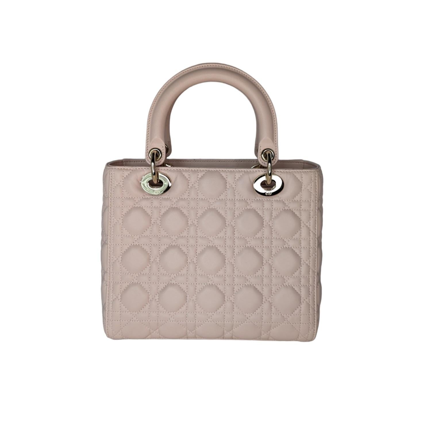 The Lady Dior bag epitomizes the House's vision of elegance and beauty. Sleek and refined, the style is timeless. It is crafted in powder pink lambskin with Cannage stitching, creating the instantly recognizable quilted texture. Pale gold-finish