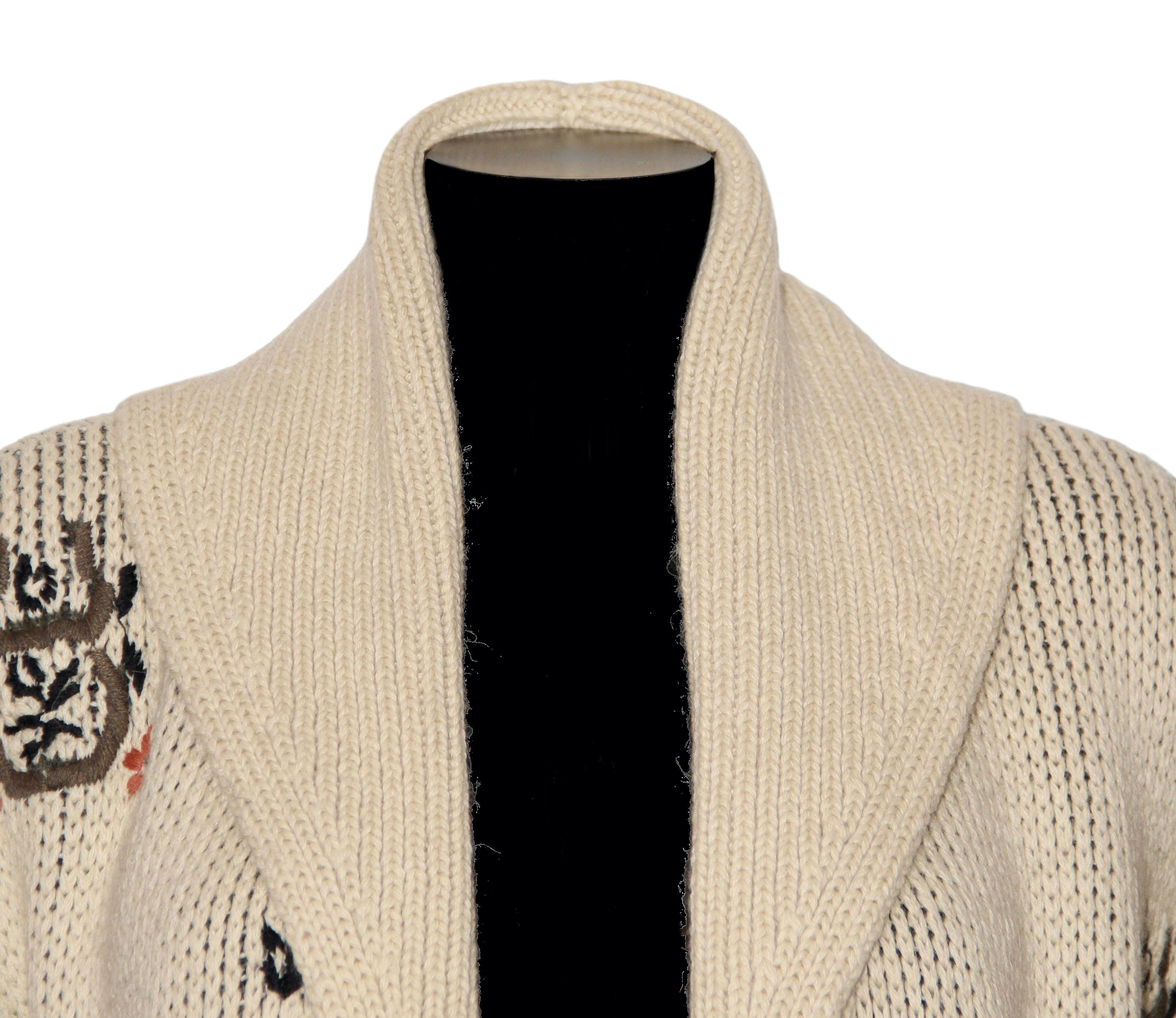This new pre-owned oversized knit wrap cardigan from the house of Christian Dior is realized in a soft virgin wool / alpaka knit.
It features a shawl collar in a rib finish all the way down to the front with a matching self-tie belt.
Its design is