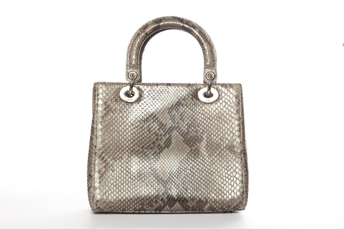 Dior grey Lady Dior bag with gold-tone hardware, optional flat leather shoulder strap featuring customizable charms, dual flat top handles, protective feet at bottom, tonal jaquard lining, single zip pocket at interior wall and zip closure at