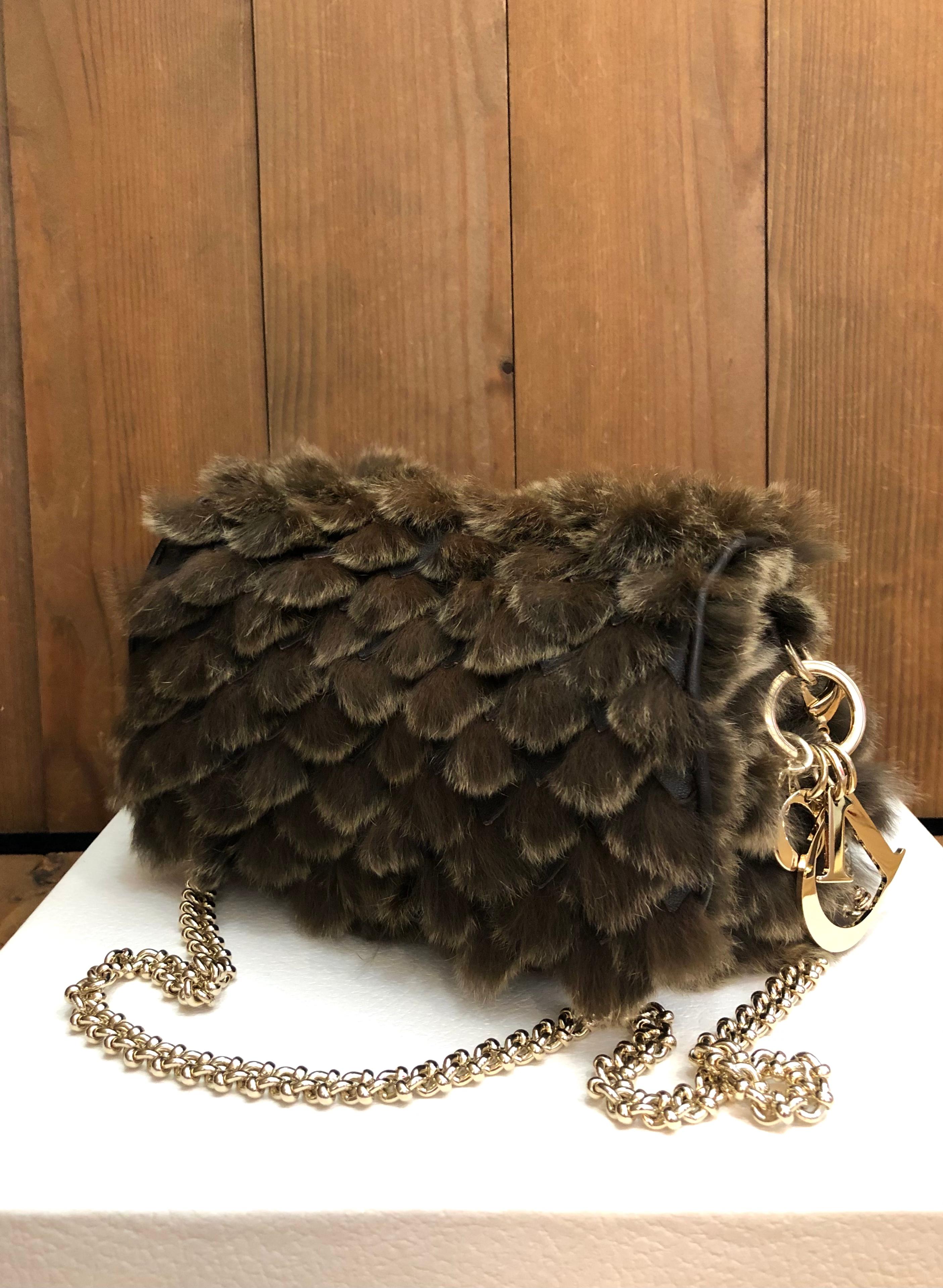 This exquisite CHRISTIAN DIOR chain bag is crafted of brown/gray rabbit and lambskin leather featuring gold toned hardware and a gold toned DIOR charm. Front flap magnetic snap closure. This Dior chain bag features a detachable gold toned chain to