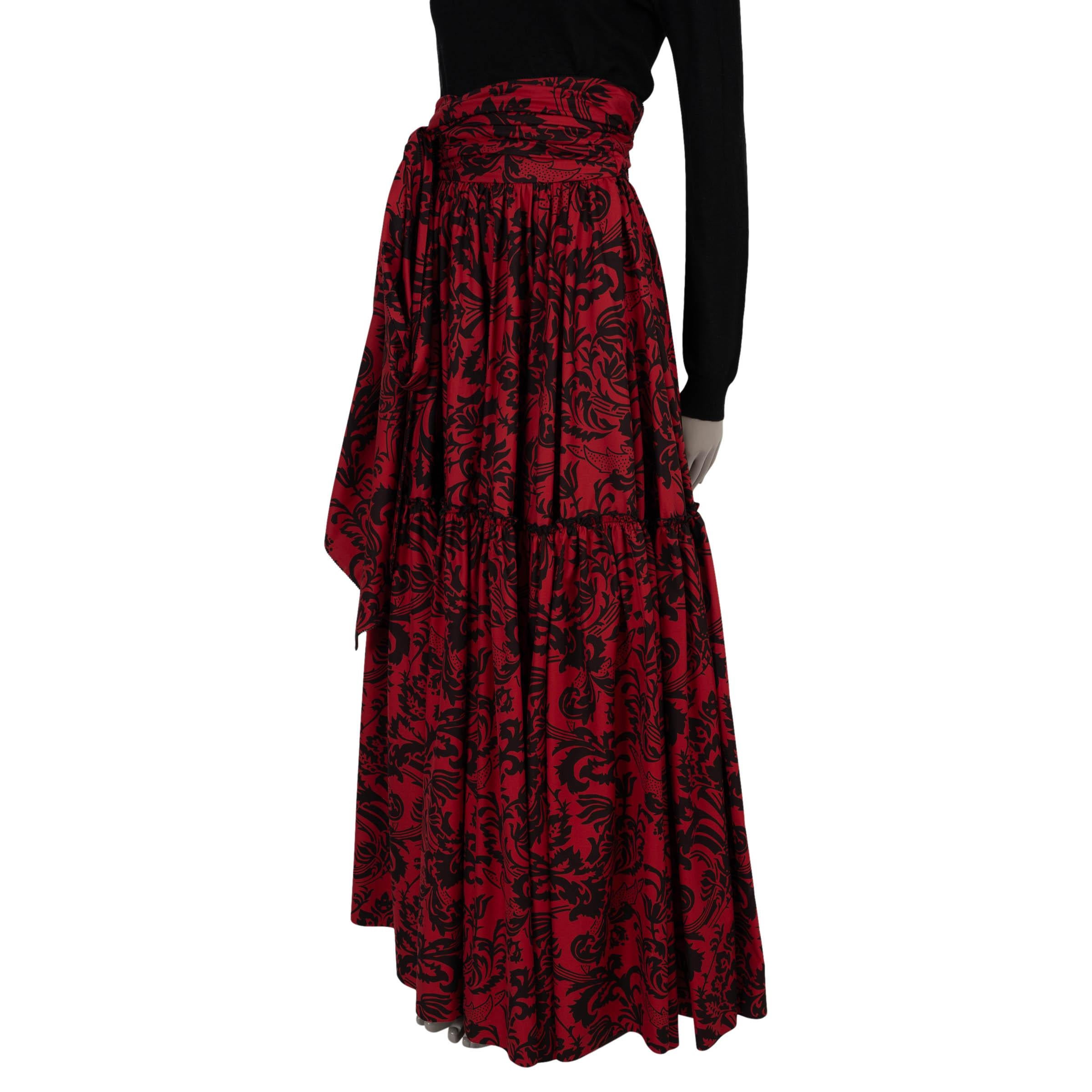 This 100% authentic Christian Dior skirt in red and black floral printed cotton (52%) and silk (48%) captures the essence of romantic elegance. Designed with a high waist and a voluminous prairie-inspired maxi silhouette, it flows effortlessly with