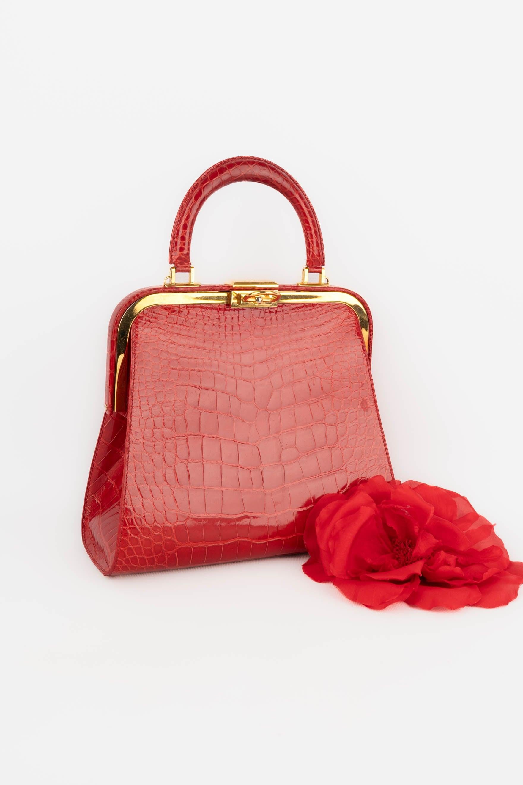 Dior - Red crocodile bag with golden metal pivoting fastener and a removable crossbody strap. 1993 circa Collection, by Gianfranco Ferre. Very good general condition, but there are traces inside.

Additional information: 
Condition: Very good