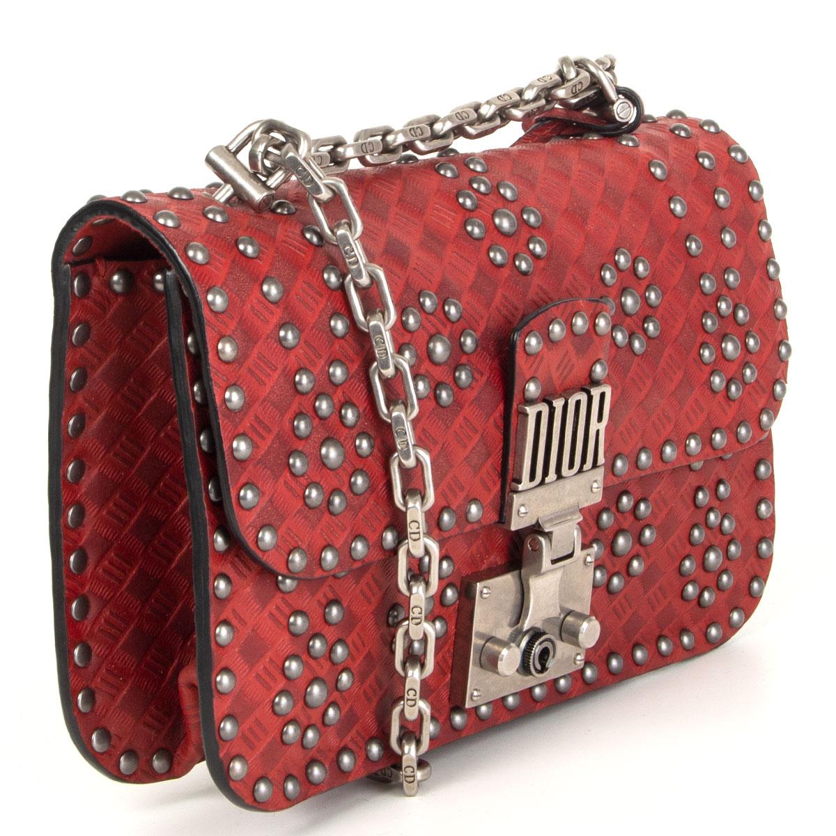 Christian Dior 'Studded Dioraddict' flap shoulder bag in embossed tomato red calfskin with gunmetal metal studds featuring silver-tone chain link shoulder strap and logo lock. Opens with a push-lock lock to a red suede lining with one zipper pocket