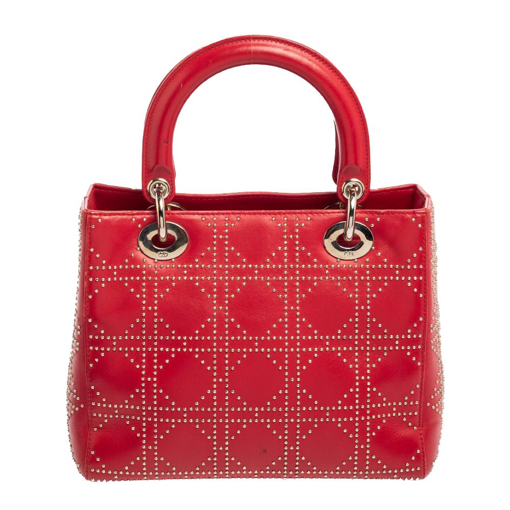 A timeless status and significant design define this Lady Dior tote. An iconic creation by Christian Dior, this tote brings eternal gracefulness and elegance to your appearance. This version is crafted using red leather, with silver-toned D.I.O.R