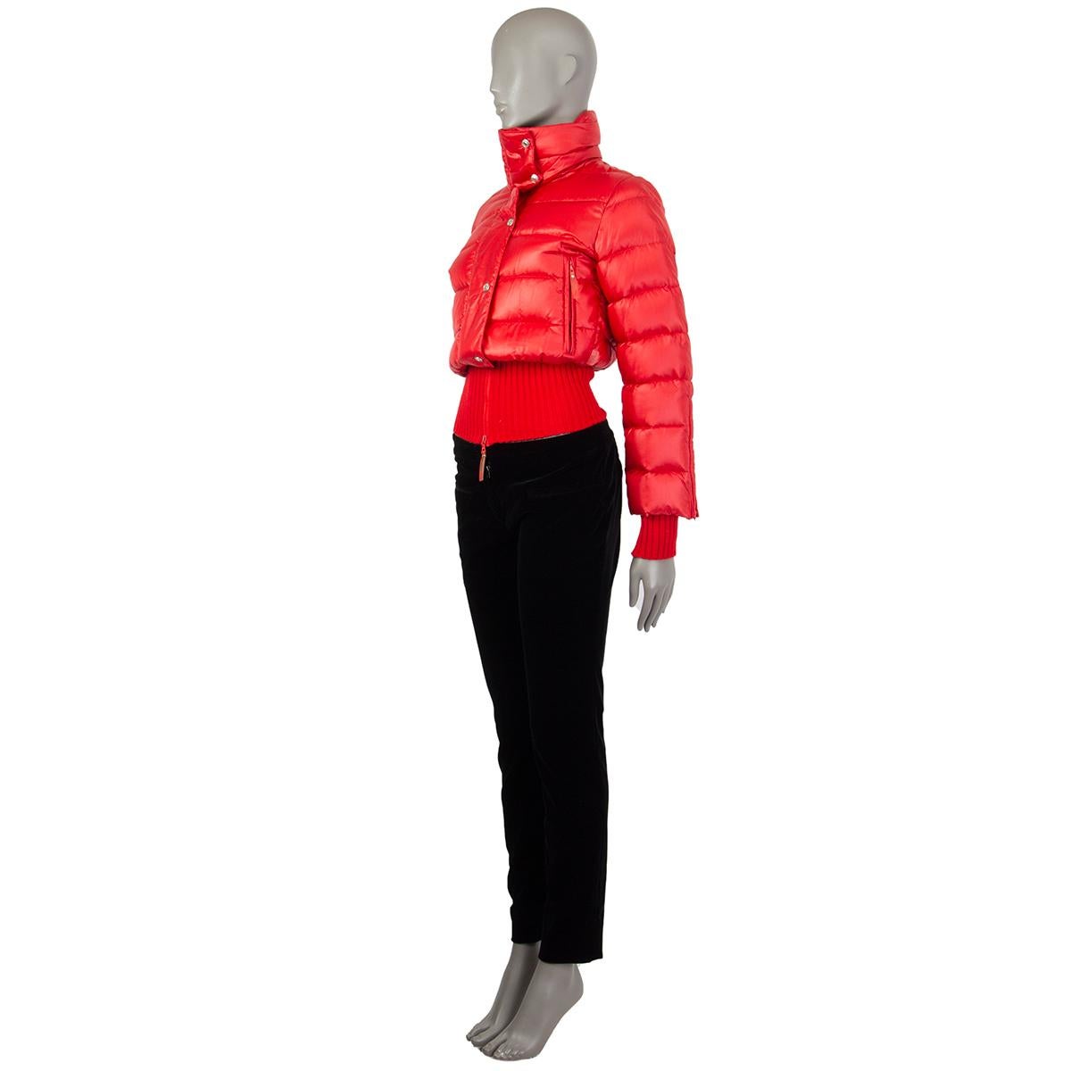 100% authentic Christian Dior puffer jacket in red nylon (100%), wool (50%), and acrylic (50%). With high collar, two zipper pockets on the sides, ribbed-knit cuffs and waist, and zipper along the sleeves. Closes with silver-tone brand snaps and