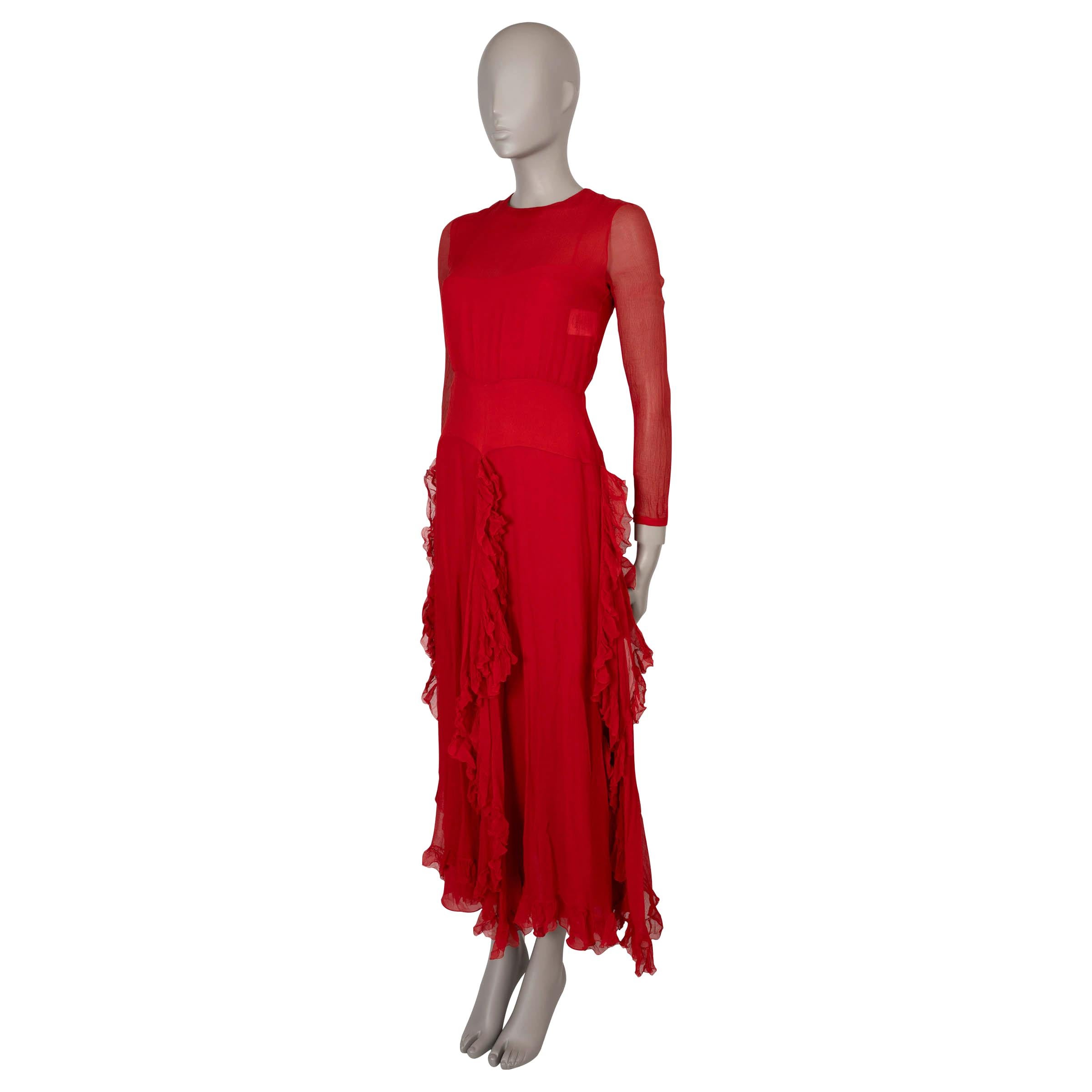 This 100% authentic Christian Dior semi-sheer evening gown in red crêpe silk exudes timeless elegance. Featuring a loose yet fitted silhouette with a maxi length, it has a graceful round neck and long sleeves. The skirt showcases ruffled trim slits
