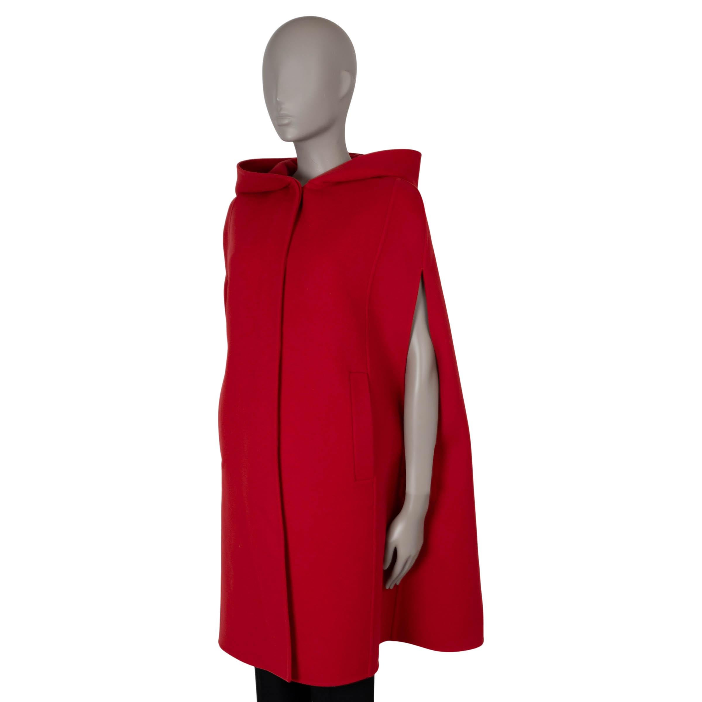 Questa mantella con cappuccio autentica al 100% di Christian Dior è realizzata in una lussuosa miscela di lana double-face rossa (90%) e cashmere (10%). Presenta un design elegante e raffinato con due tasche a fessura sul davanti e si chiude con