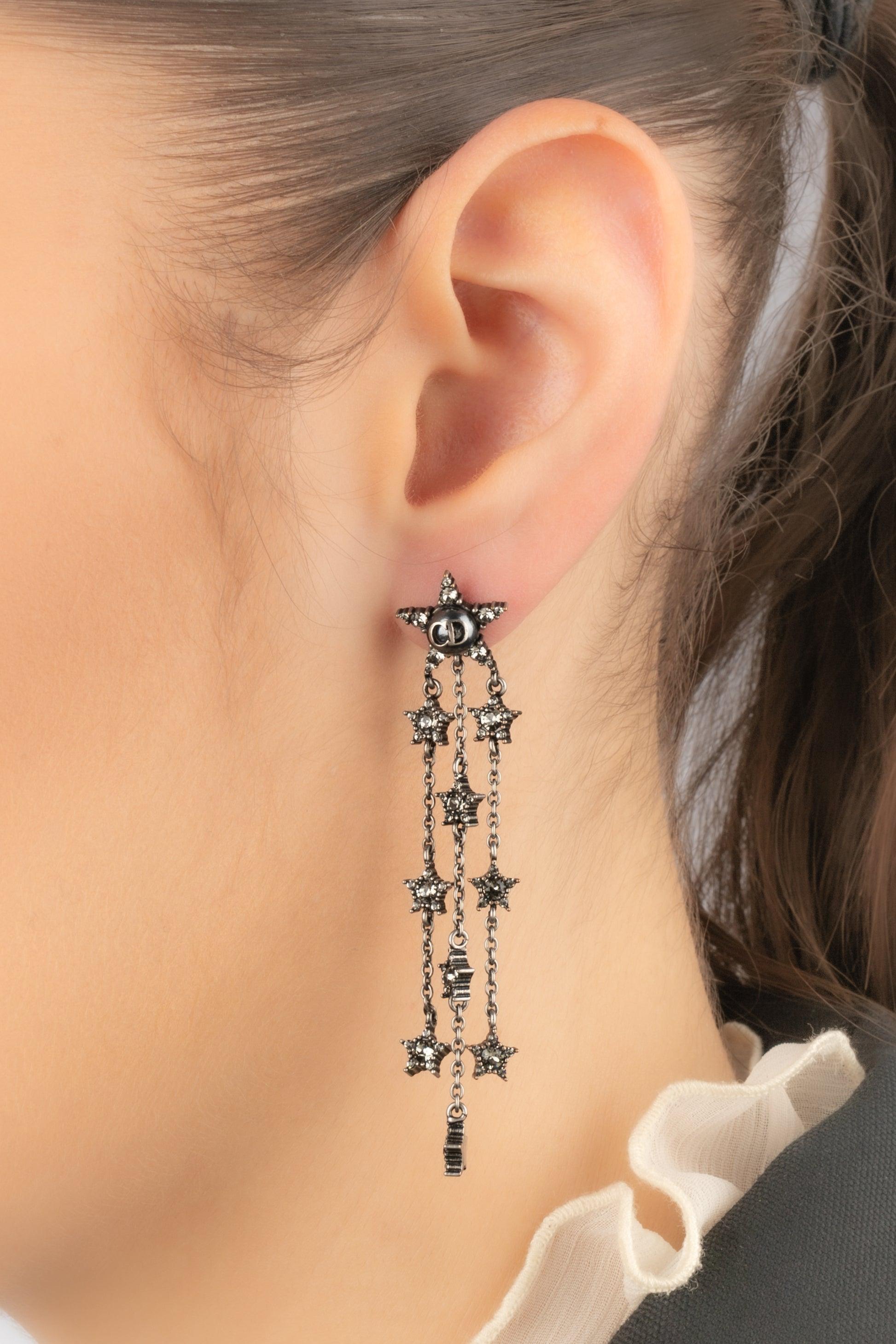 Dior - Single earring representing rhinestoned dark-silvery metal stars.

Additional information:
Condition: Very good condition
Dimensions: Length: 7 cm

Seller Reference: BO414