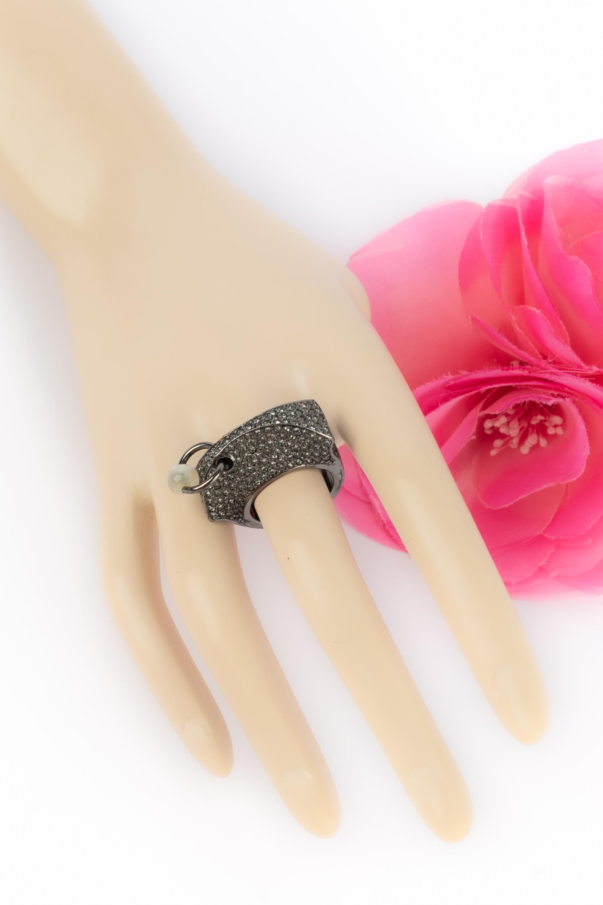DIOR - Silvery metal ring ornamented with rhinestones, and with a resin pearl.

Condition:
Very good condition

Dimensions:
Size 52

SKU: