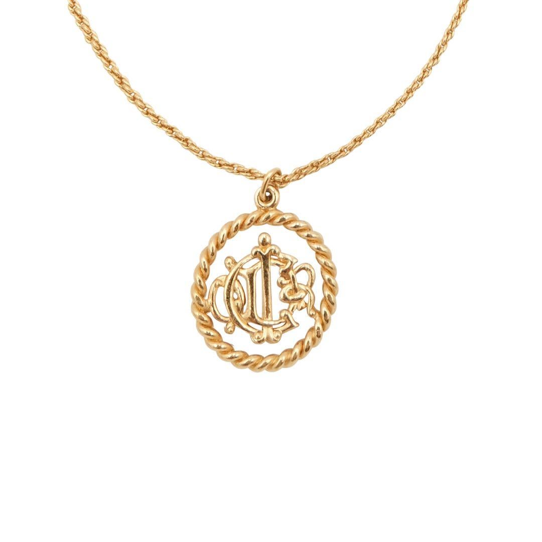 Vintage Christian Dior gold plated rope chain necklace with circular abstract logo charm.

Condition Details: In excellent, gently used condition consistent with its age and use. There is light scratching to the gold plating in some places; however,