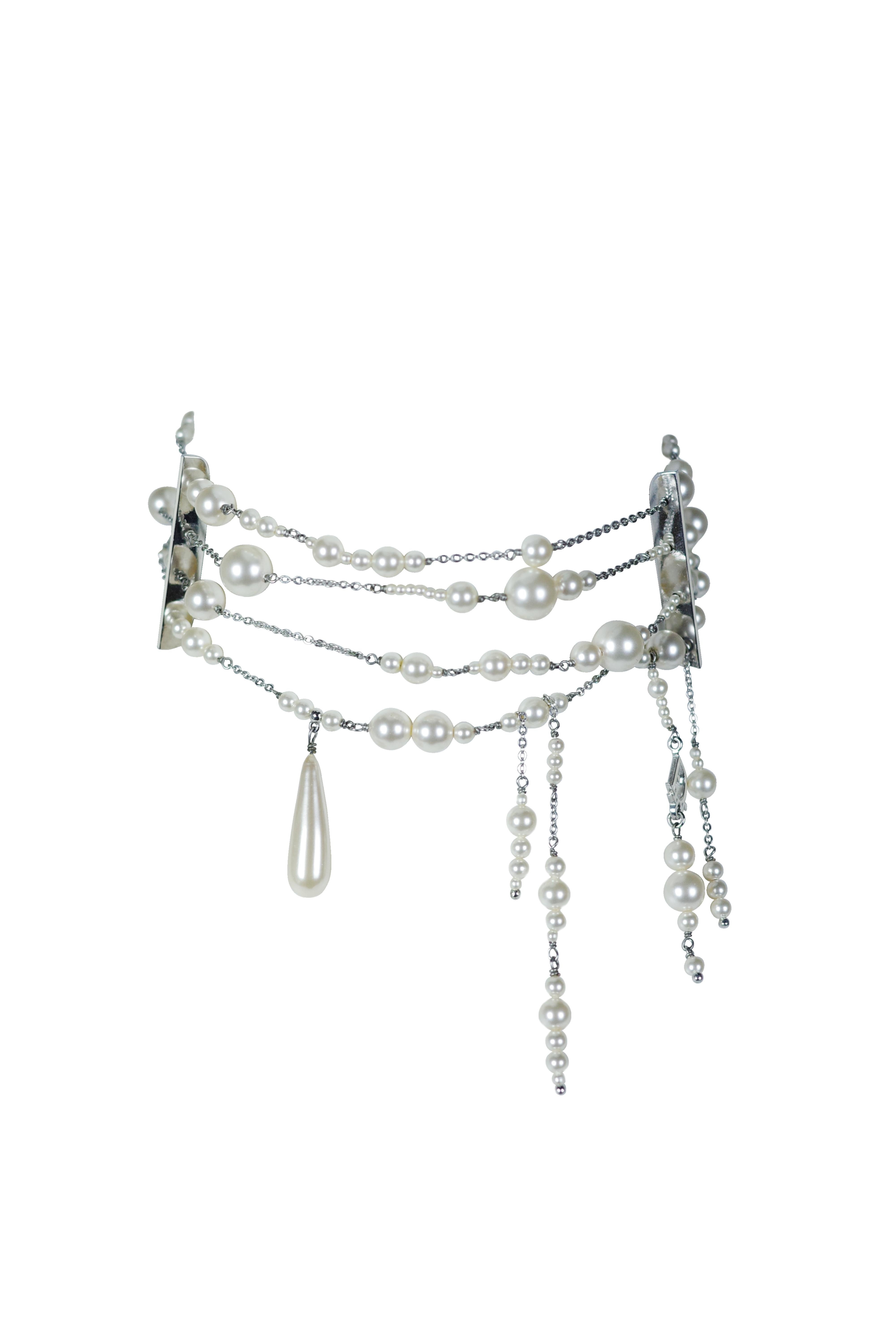 Esta elegante gargantilla Dior presenta múltiples hilos de brillantes cristales y perlas, creando un accesorio delicado pero llamativo. El diseño incluye perlas colocadas asimétricamente y un prominente colgante de perlas en forma de lágrima, que