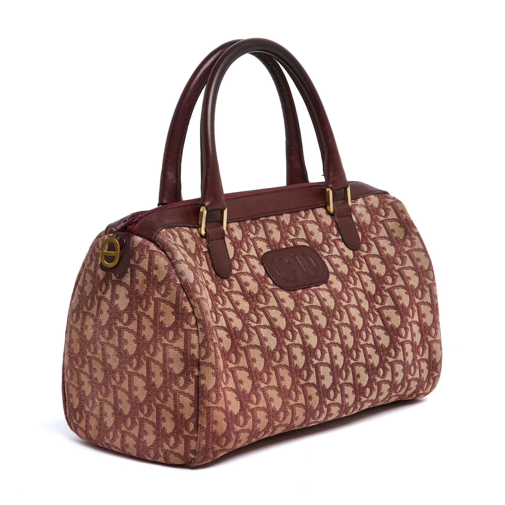 Christian Dior Speedy or Boston bag in burgundy on ecru Dior Oblique canvas and burgundy leather, burgundy leather interior, closed by a burgundy zip with a CD logo pull in gold metal. Width 30 cm x height 18 cm x depth 14 cm, handles 36 cm. The