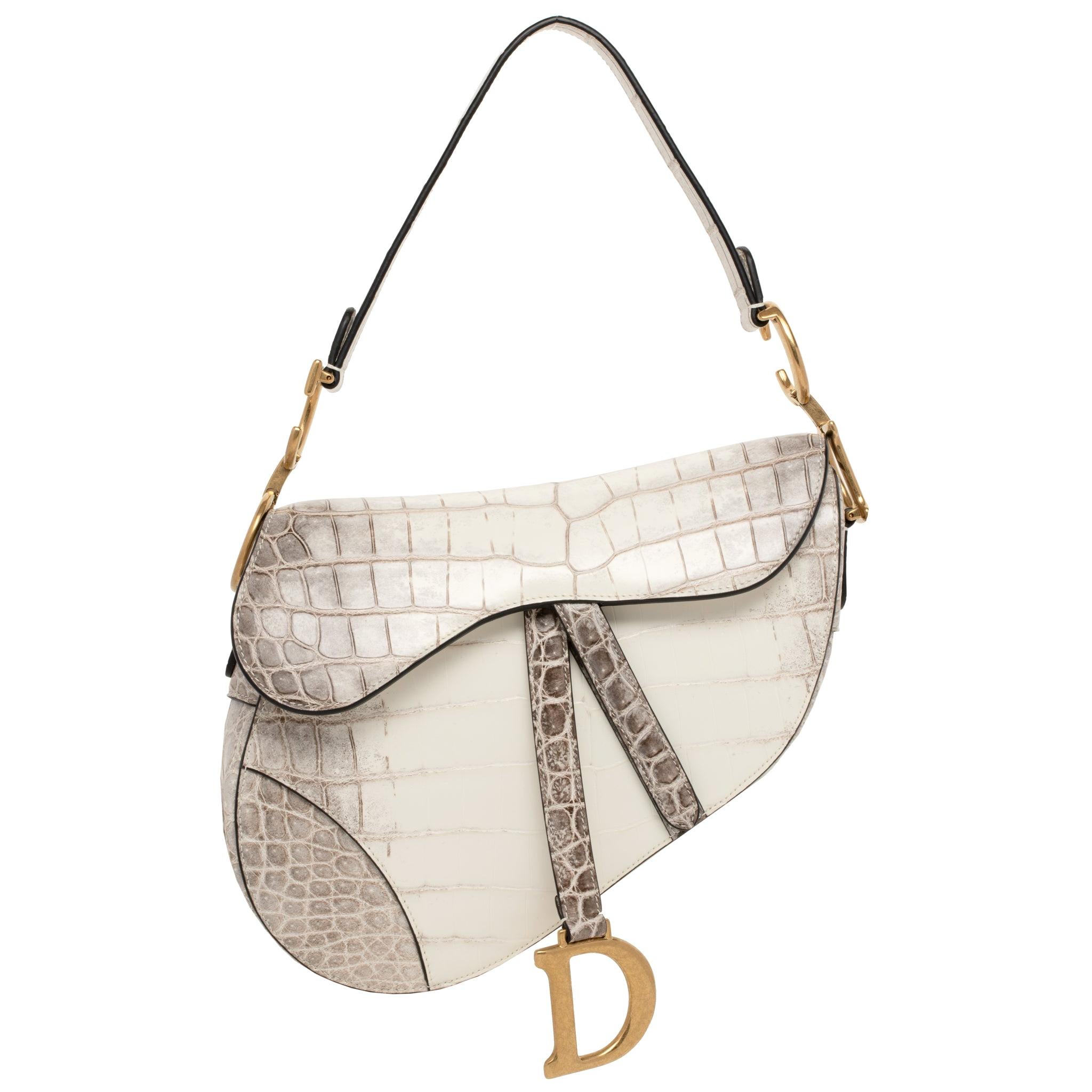 1stdibs Exclusives From Three Over Six

Brand: Christian Dior
Style: Saddle Bag
Size: Medium 25.5 x 20 x 6.5 cm
Color: Blanc Casse Himalayan
Leather: Matte Niloticus Crocodile
Hardware: Aged Gold
Year of Production: 2019

Condition: Pristine, never