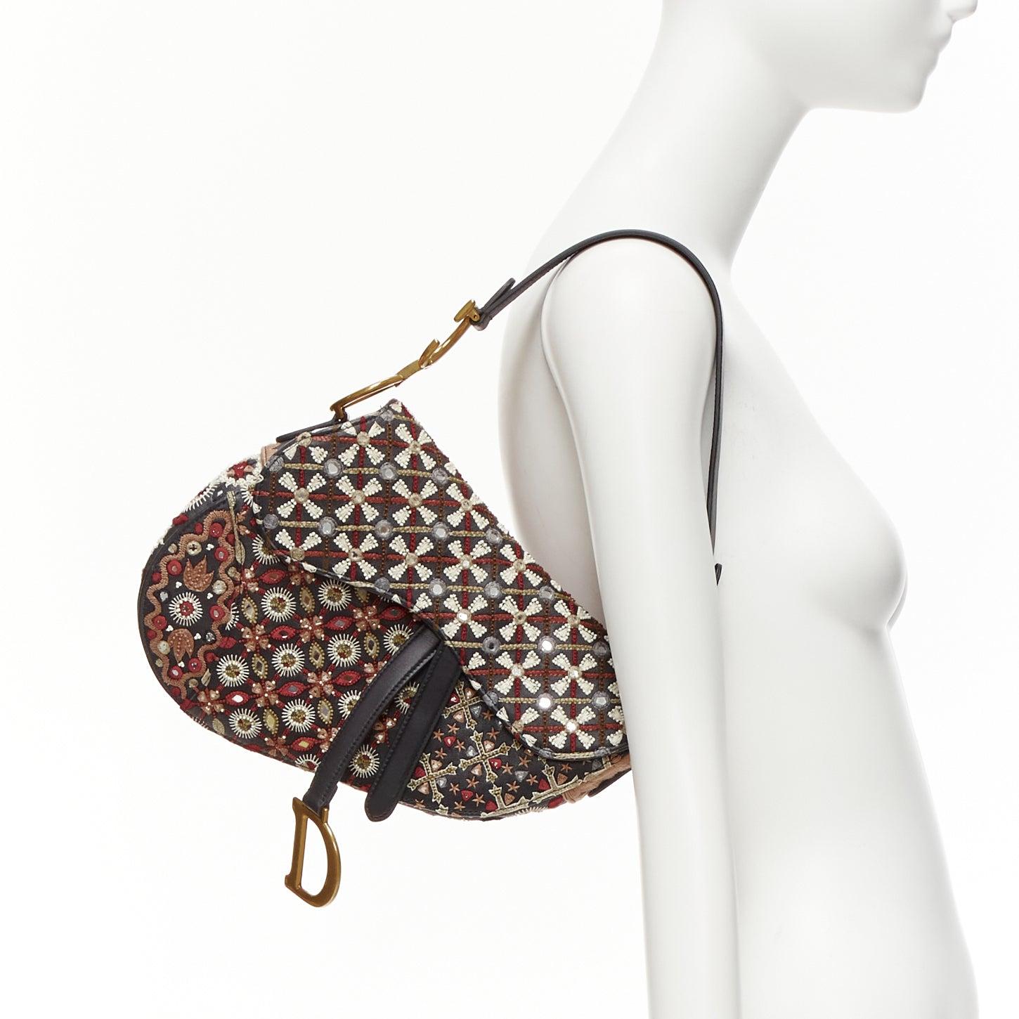 CHRISTIAN DIOR Saddle Limited Edition black colourful ethnic beads shoulder bag
Reference: AAWC/A00945
Brand: Dior
Model: Saddle
Collection: Limited Edition
Material: Leather, Metal
Color: Multicolour, Black
Pattern: Solid
Closure: Magnet
Lining: