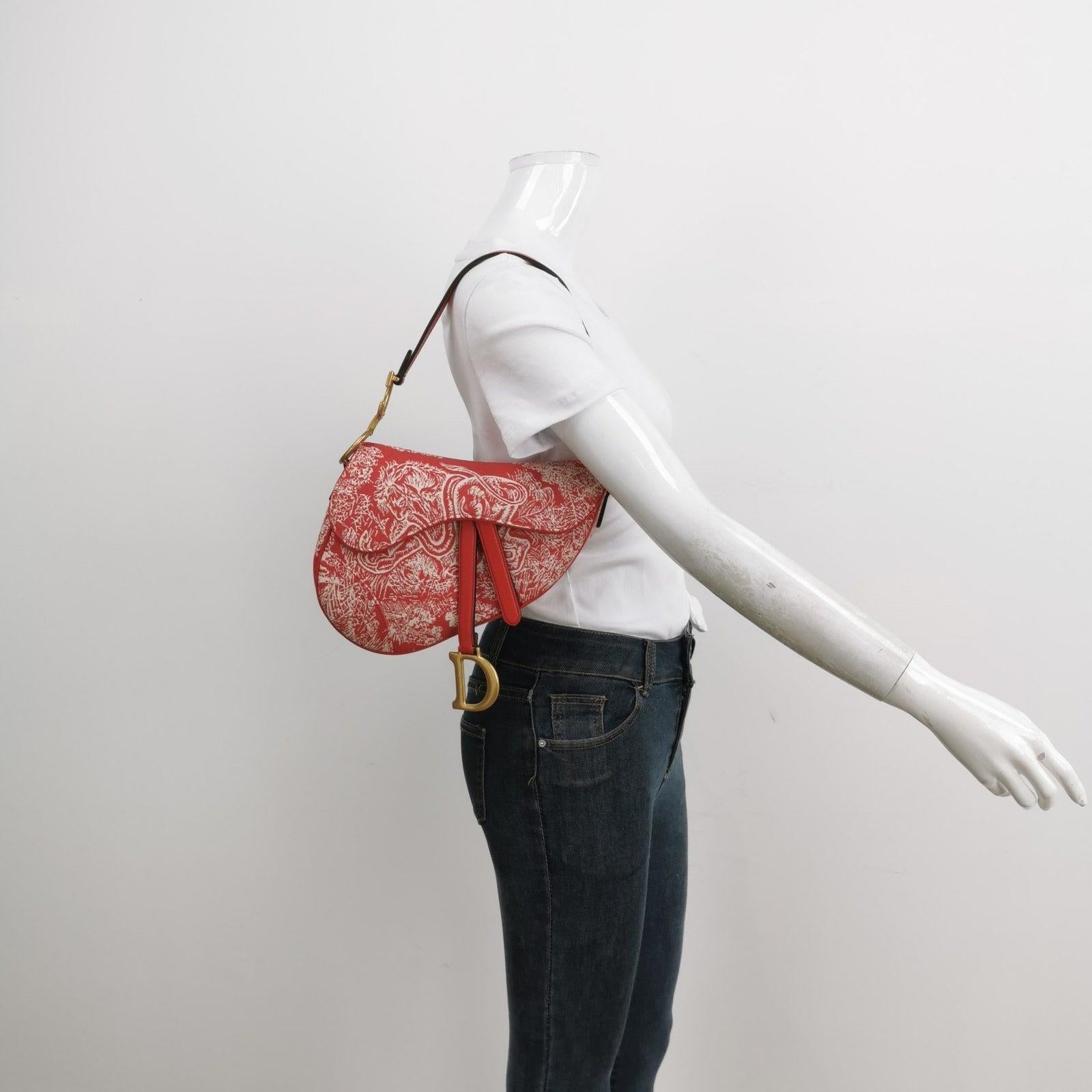 Christian Dior Saddle Medium Red Canvas Animal Prints Tiger Snake Monkey These are professional photos of the actual bag offered by Luxbags. This medium-sized Dior Saddle bag is constructed from canvas with rainforest prints and animal prints such
