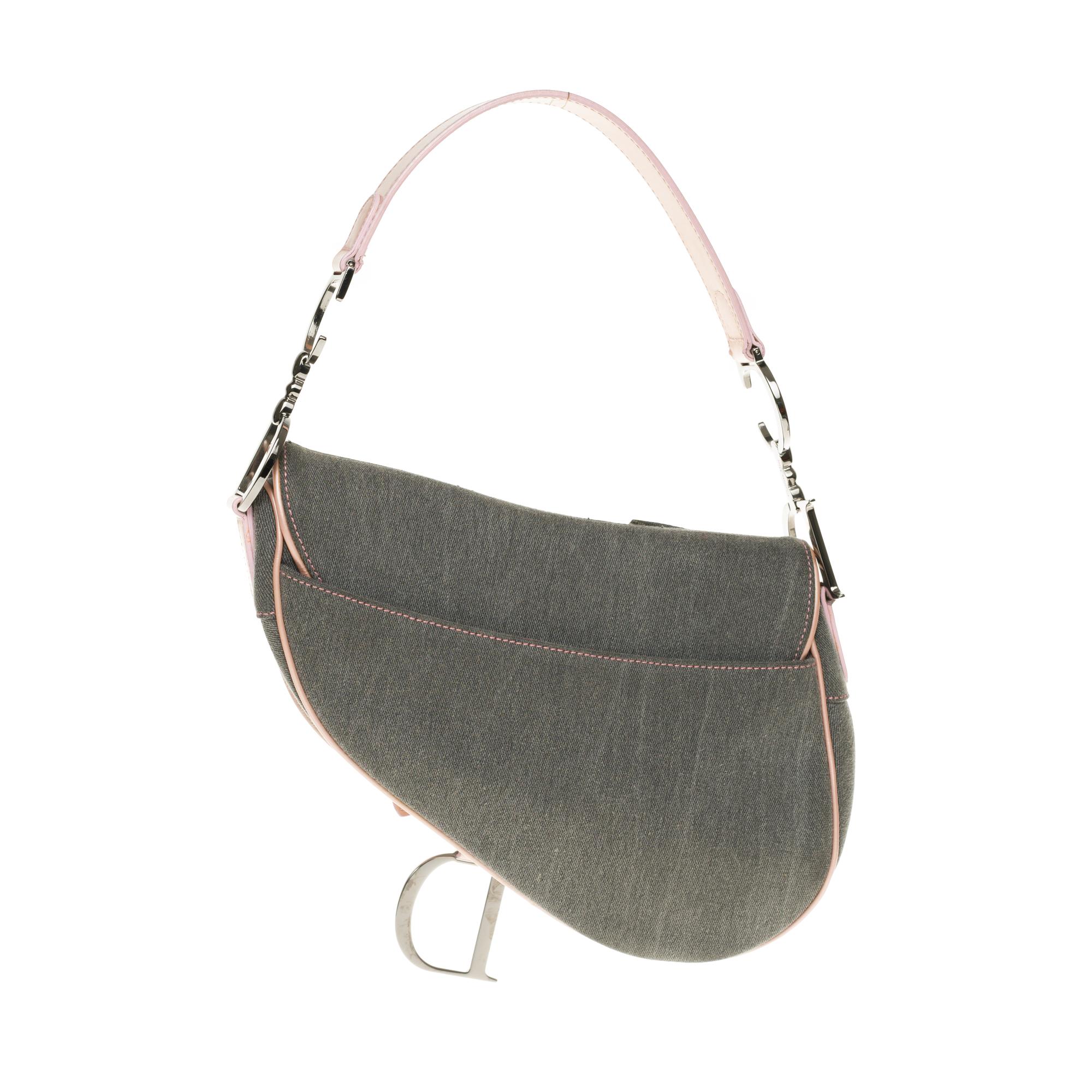 Lovely Dior handbag in blue denim canvas and pink patent leather, silver metal trim, a thin pink patent leather handle allowing a shoulder strap.

Leather flap closure.
A thin pocket on the back of the bag.
Monogrammed black satin inner lining, one