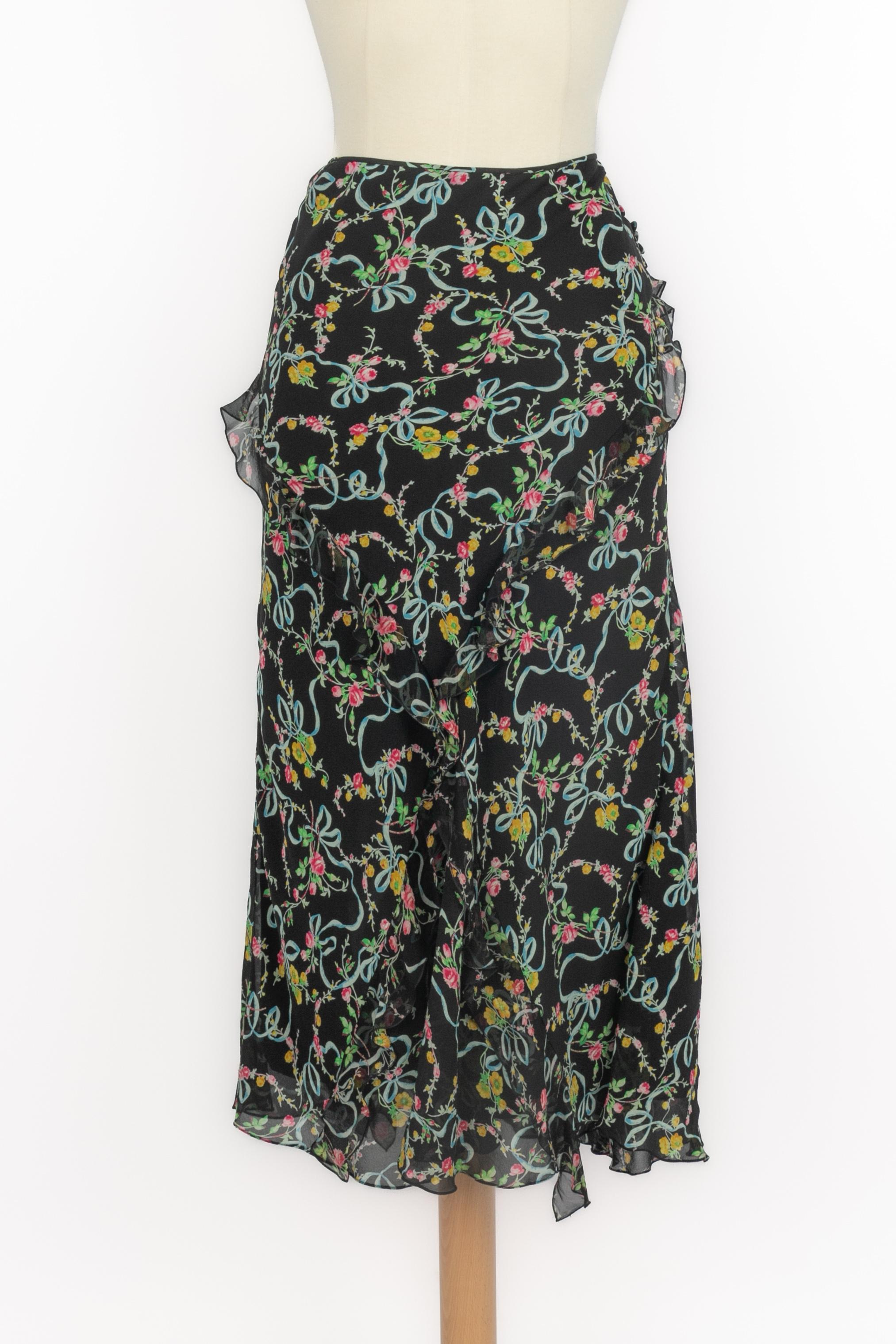 DIOR - (Made in France) Ensemble composé d'une jupe en soie à motif fleuri sur fond noir, d'un top en maille stretch et soie noire, et d'un cardigan en maille noire et soie transparente à motif fleuri. Taille 40FR/42FR indiquée. A 2004 Collectional,