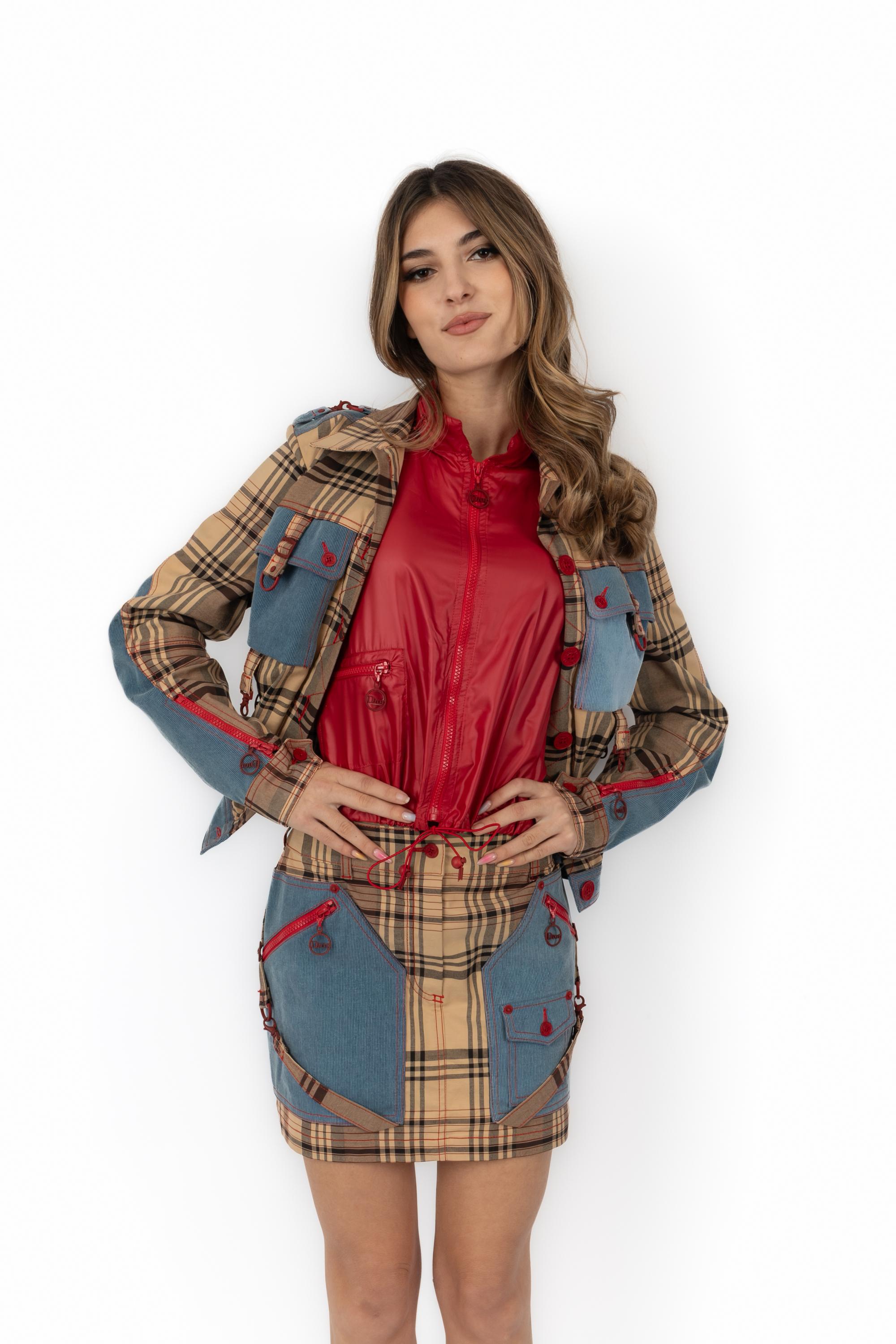 DIOR - (Made in Italy) Conjunto con estampado de tartán compuesto por una minifalda y una chaqueta, rematadas con parches vaqueros de pana. Elementos metálicos rojos y forro de lona cortavientos roja. Se indica la talla 36FR. Una Colección 2004 bajo