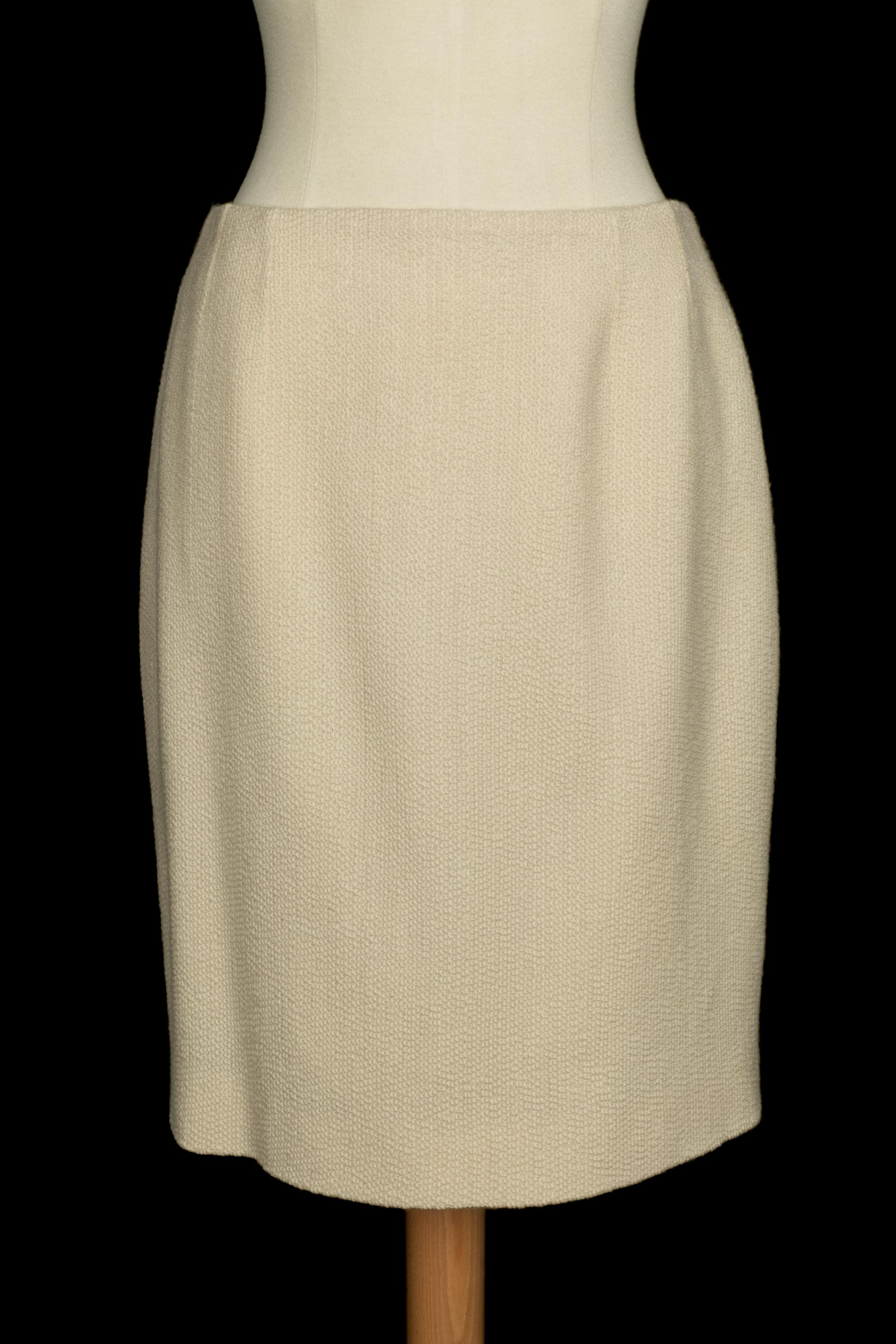 DIOR - (Fabricado en Francia) Conjunto de lana beige compuesto por una falda y una chaqueta, con forro de seda. Cuello pespunteado con encaje blanco. Bajos de mangas decorados con trenzas y encaje. Talla 40 FR indicada. Colección Primavera-Verano