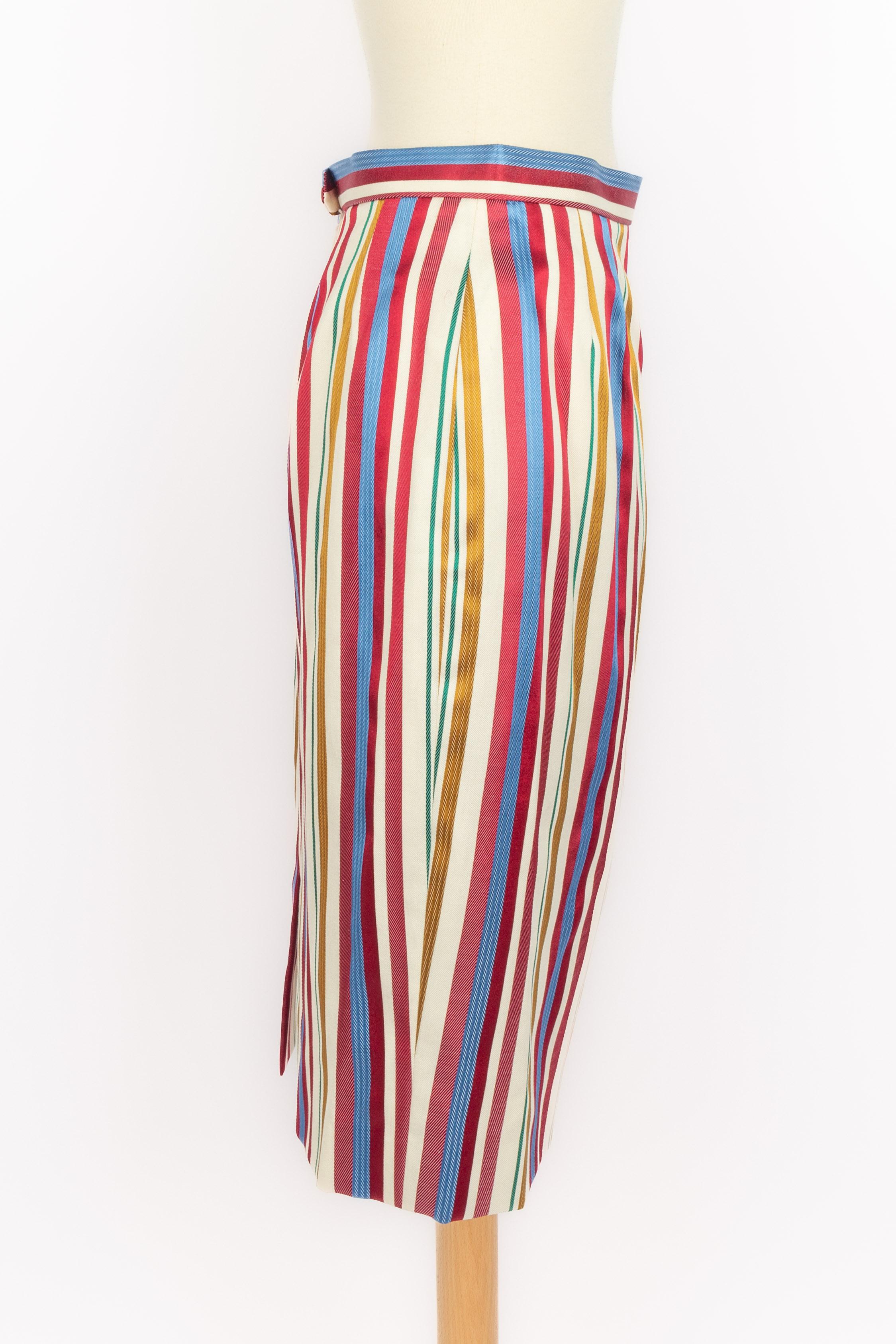 DIOR - (Fabriqué en France) Ensemble en soie et coton rayé multicolore bordé de passementerie, composé d'une veste à manches courtes et d'une jupe mi-longue. Taille 40FR indiquée. Collectional printemps-été 1996 sous la direction artistique de