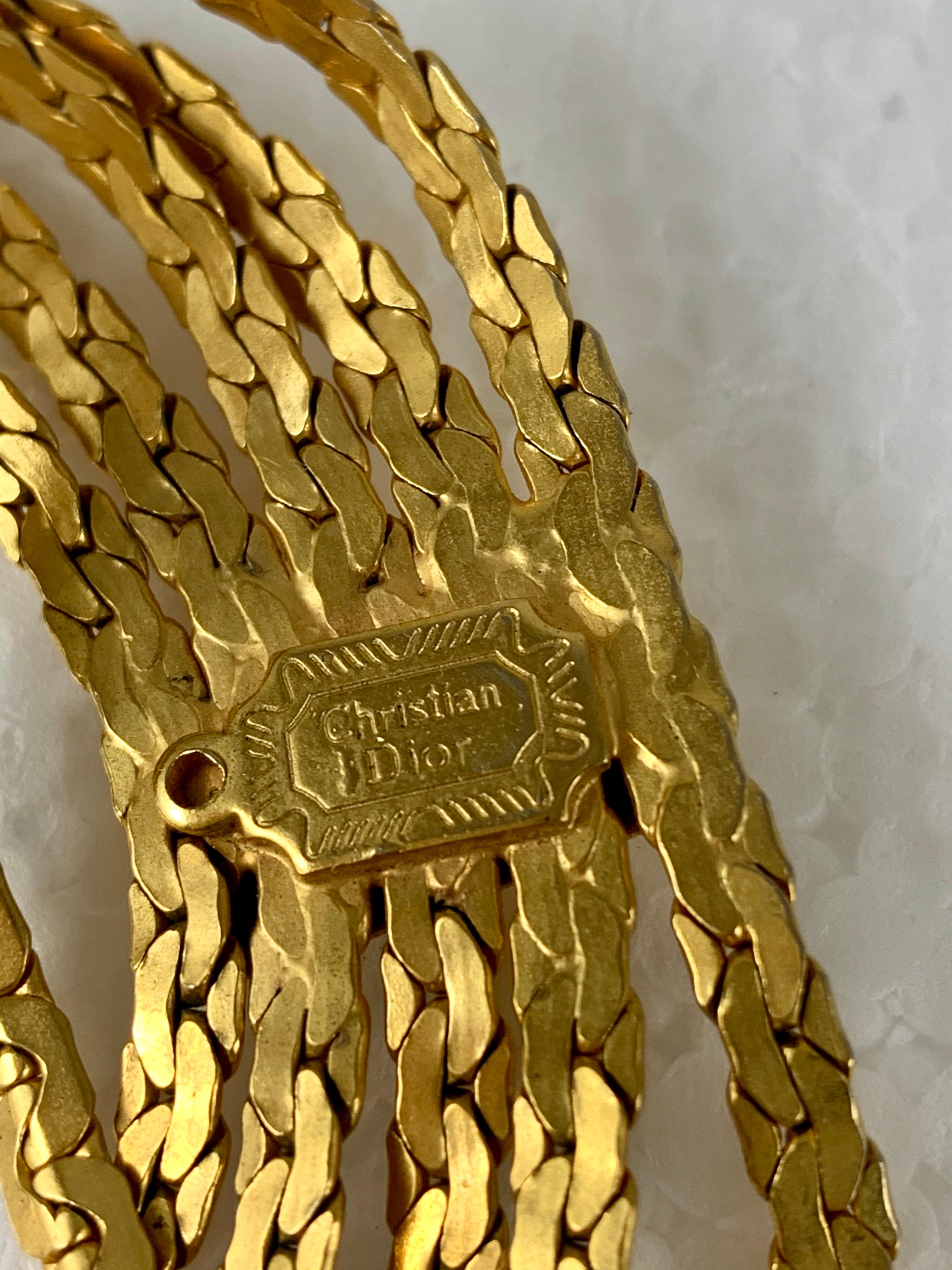 From Christian Dior, France, a 1960s Era belt made of five gold-tone snake chains bound at three intervals with soldered rectangular stations. The chains hang in a graceful swag. The Christian Dior stamped logo is applied to the verso of one