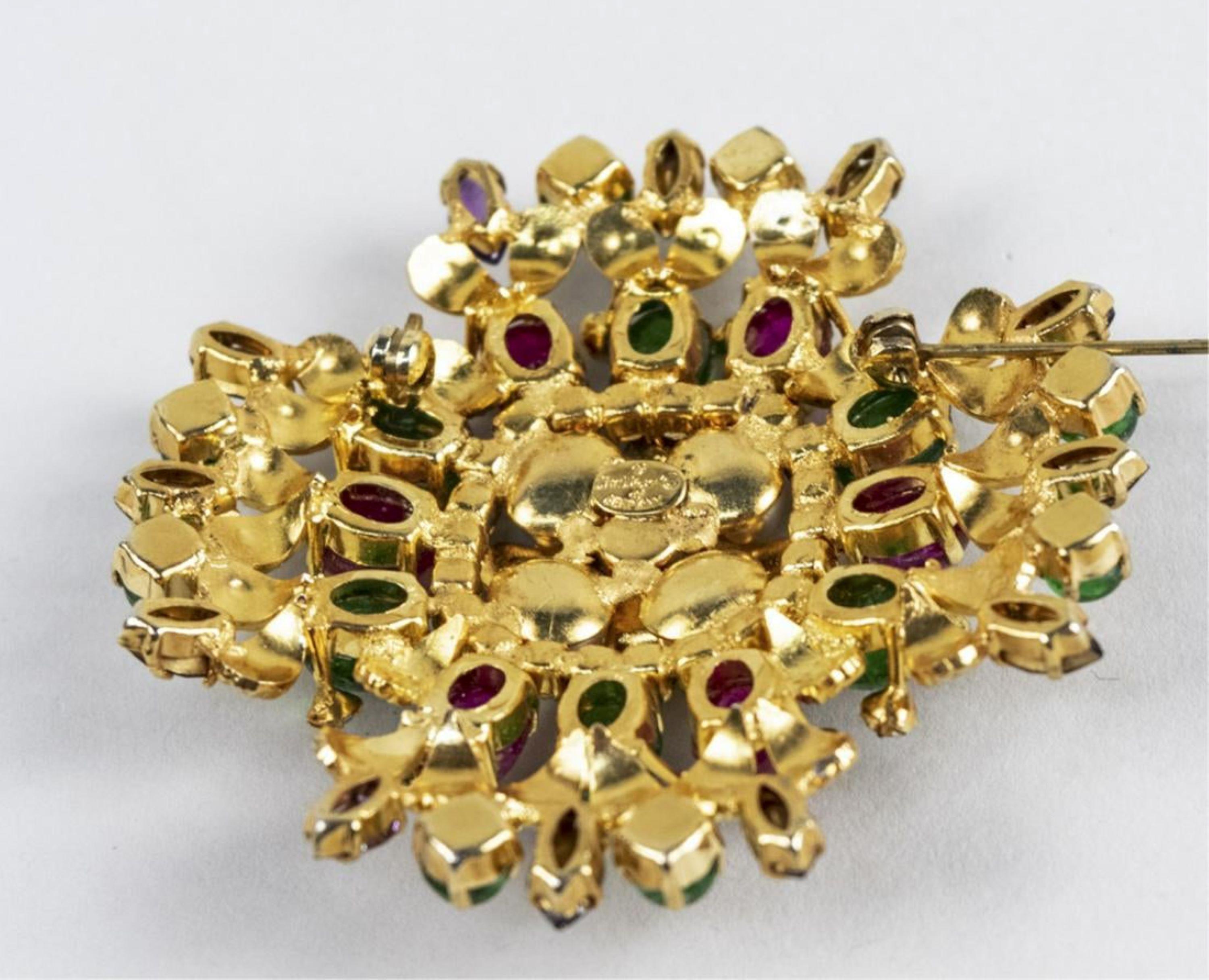 Shaped circular brooch with simulated pearls, emeralds, rubies, and diamonds. Signed. Diameter 2 1/4 in.