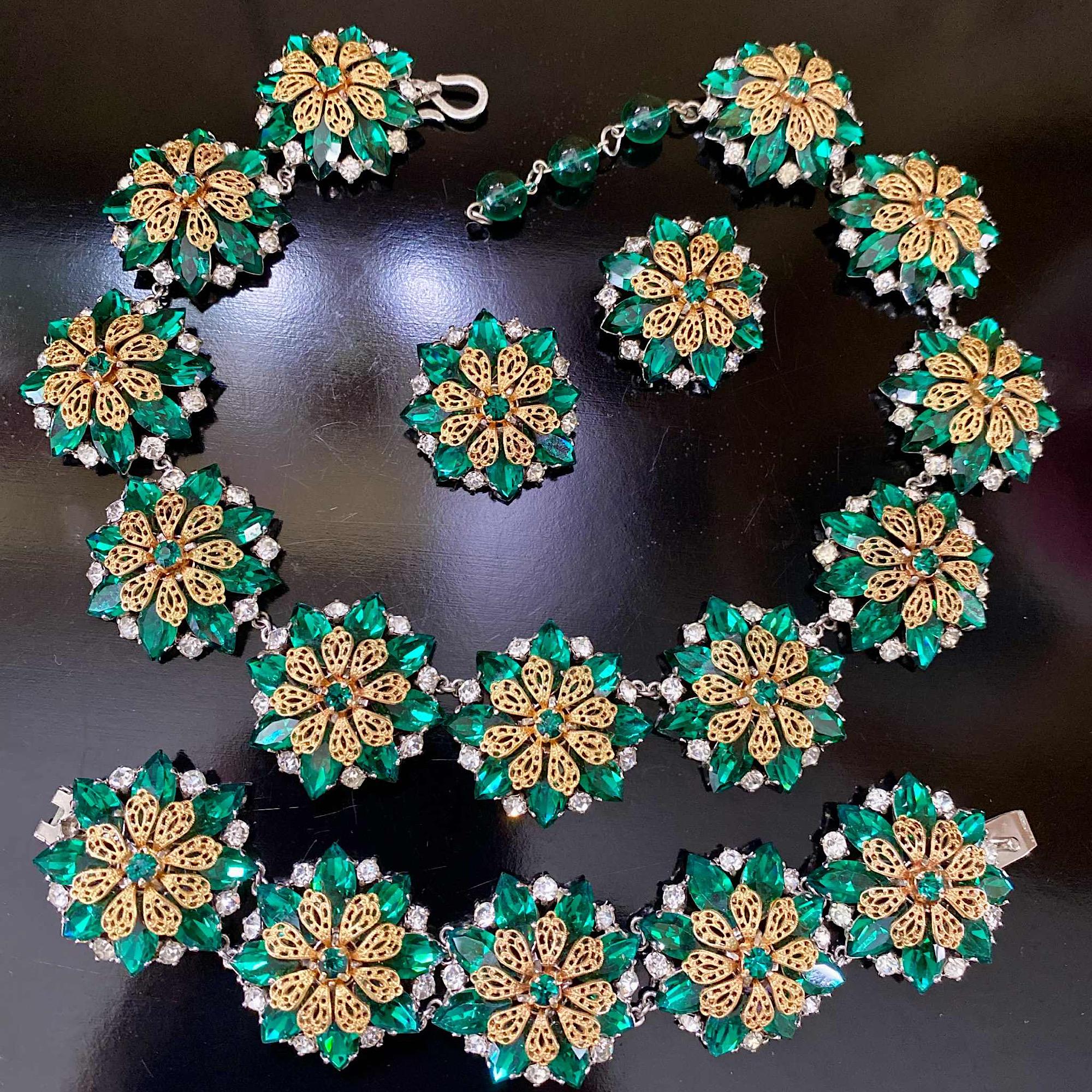 Una rara parure di Christian Dior dei primi anni '50, composta da collana, bracciale e orecchini.

Questa bellissima e rara parure è molto appariscente, con un design a forma di pannelli floreali rotondi incastonati con navette di cristallo verde