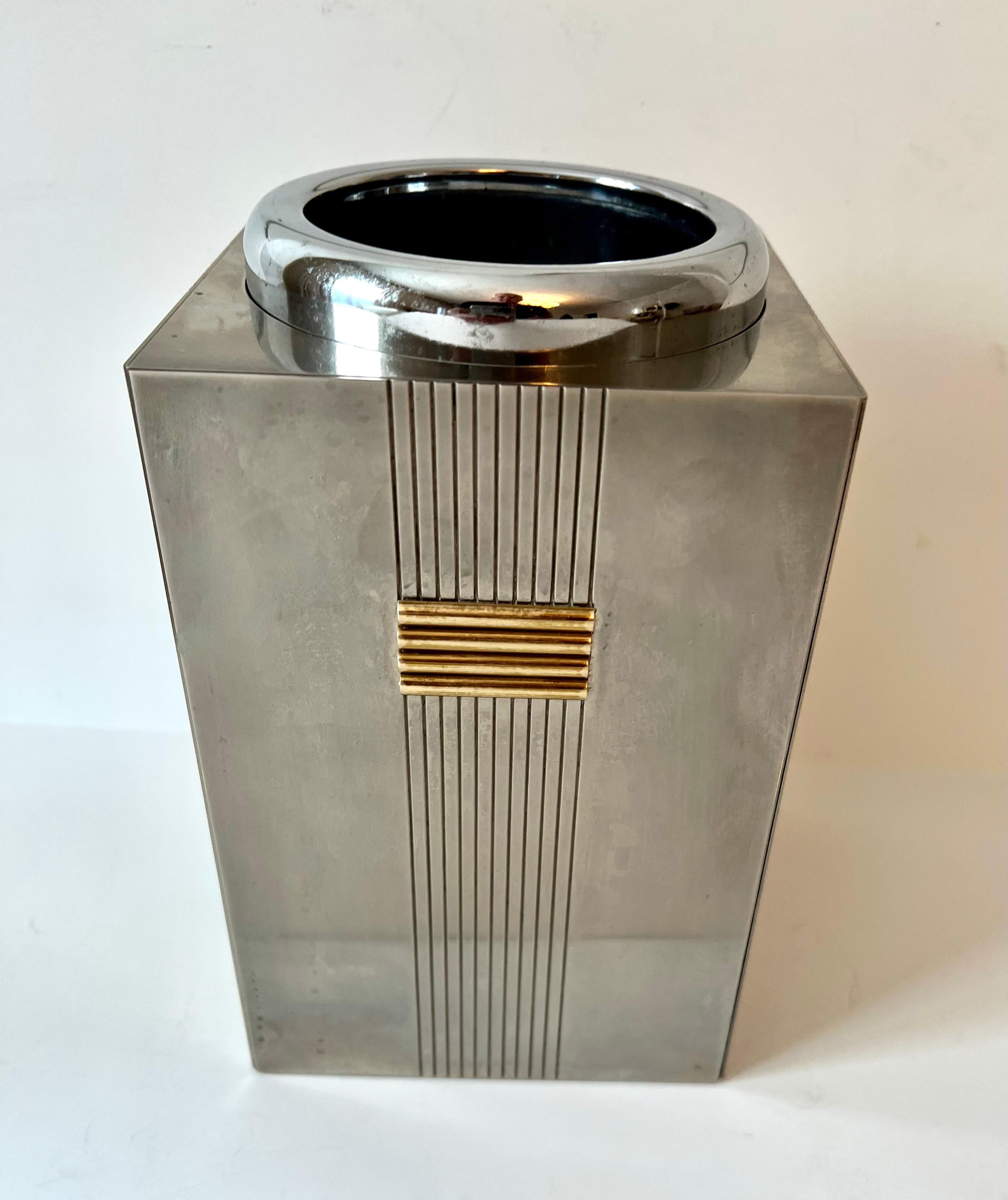 Christian Dior Champagne and wind cooler. The piece has a very easy to remove insert for chilling... the exterior is a luxurious shine with a ridge detail with gold bar details. 

A must have for any sophisticated bar. Makes a wonderful